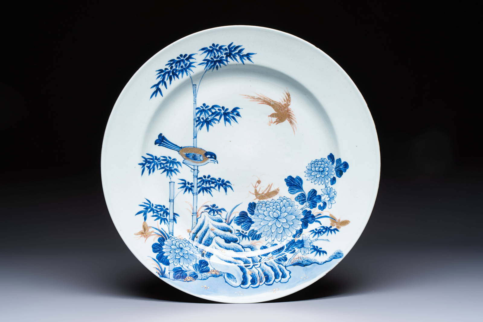 A large Chinese blue and white gilt-decorated dish with birds and insects among bamboo and peonies,