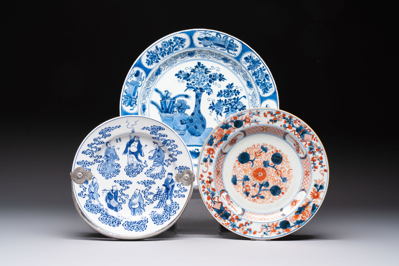 Three Chinese blue, white and Imari-style plates, Xuande and Zhi mark, Kangxi and later: Three Chinese blue, white and Imari-style plates, Xuande and Zhi mark, Kangxi and later Dia.: 35,4 cm (the largest) Dia.: 26 cm (the smallest incl. silver mount)