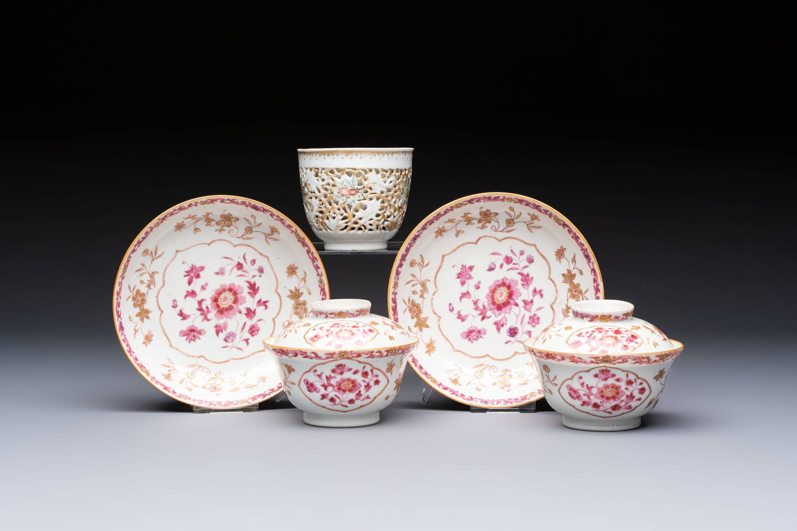 A pair of Chinese famille rose gilt-decorated covered cups and saucers and an openworked cup,