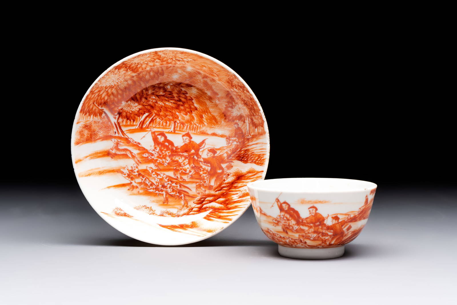A Chinese iron-red-decorated 'Deer Hunting' cup and saucer, Qianlong