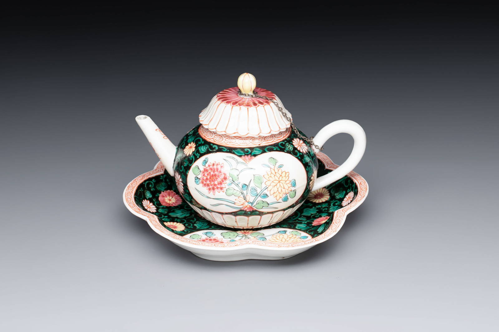A Chinese famille rose black-ground teapot and stand with floral design, Yongzheng/Qianlong