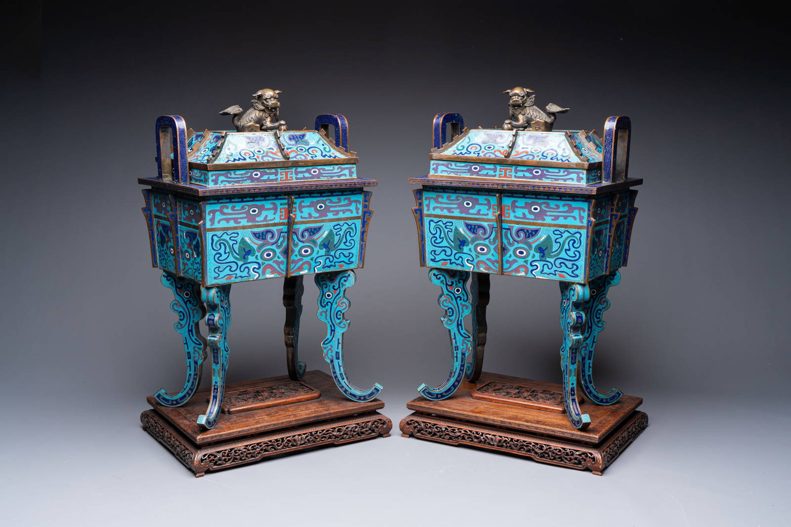 A pair of Chinese cloisonné 'Fangding' censers and covers with Taotie design on carved wooden