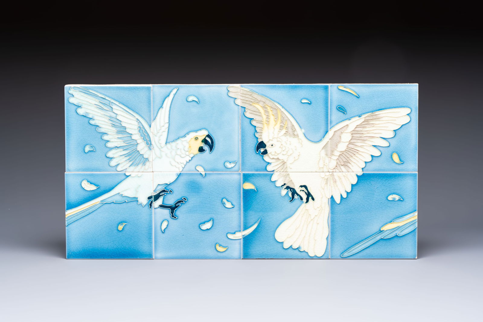 An Art Nouveau 'Cockatoos' tile mural, Gilliot et Cie., Hemiksem, 19/20th C.: An Art Nouveau 'Cockatoos' tile mural, Gilliot et Cie., Hemiksem, 19/20th C. Dim.: 61 x 30,8 cm (the mural) Dim.: 15,5 x 15,5 cm (each tile)