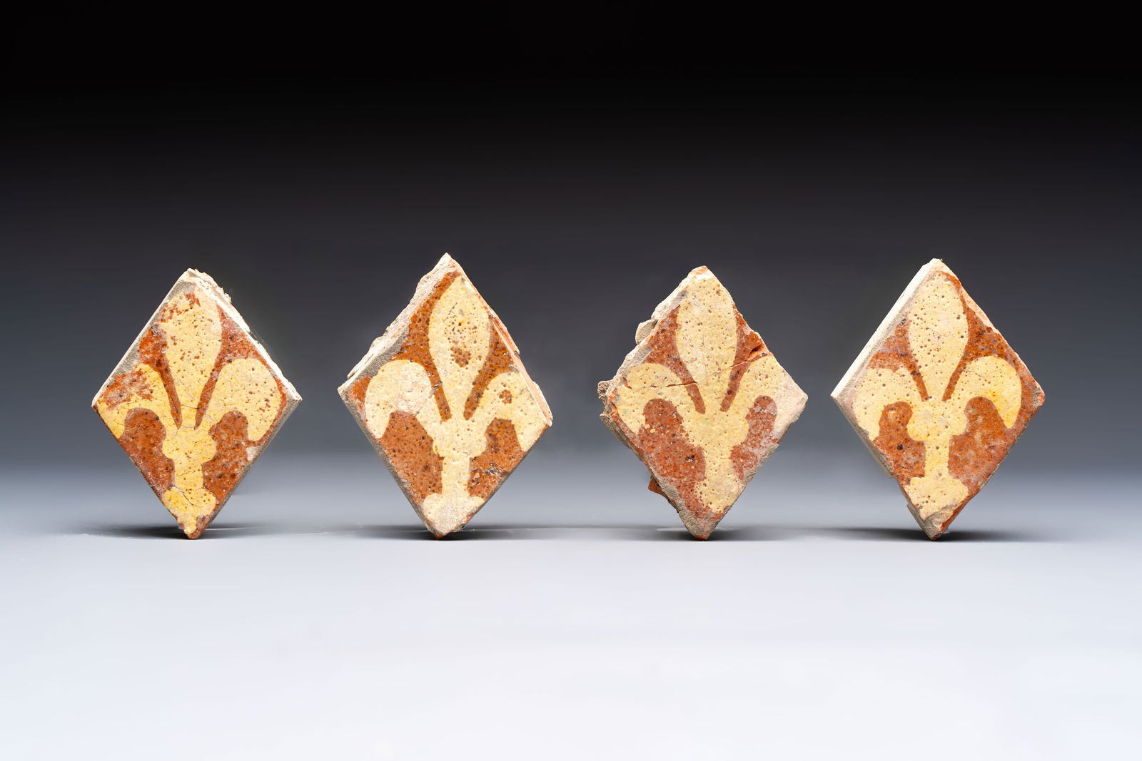 Four medieval slip-decorated ‘Fleur-de-Lys’ tiles, France, 15/16th C.: Four medieval slip-decorated ‘Fleur-de-Lys’ tiles, France, 15/16th C. Dim.: 11,2 x 8,2 x 3,3 cm (the largest) Dim.: 10,9 x 7,9 x 3,1 cm (the smallest)