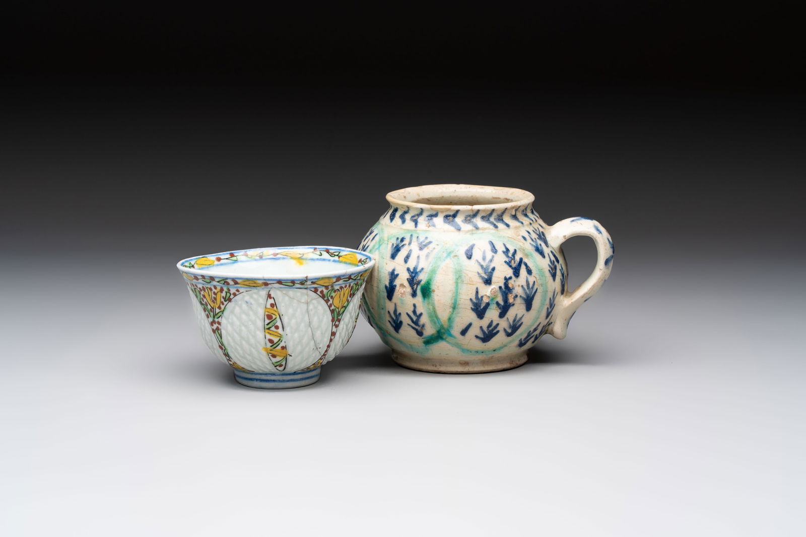 A polychrome pottery Kutahya cup and a mug, Turkey, 18th C.: A polychrome pottery Kutahya cup and a mug, Turkey, 18th C. L.: 12 cm - H.: 8,4 cm (the mug) Dia.: 9 cm - H.: 5,6 cm (the cup) Ref.:Christie's, London, Oct. 24, 2024, lot 101, for a very similar Kutah