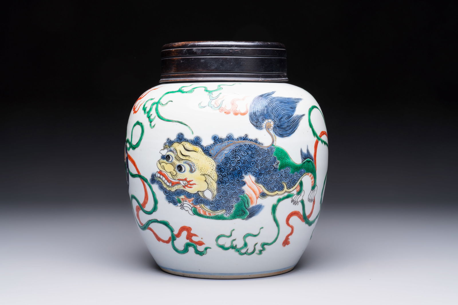 A fine Chinese famille verte 'Buddhist Lions' jar and a reticulated wooden cover, 19th C.: A fine Chinese famille verte 'Buddhist Lions' jar and a reticulated wooden cover, 19th C. H.: 23,5 cm (incl. cover)