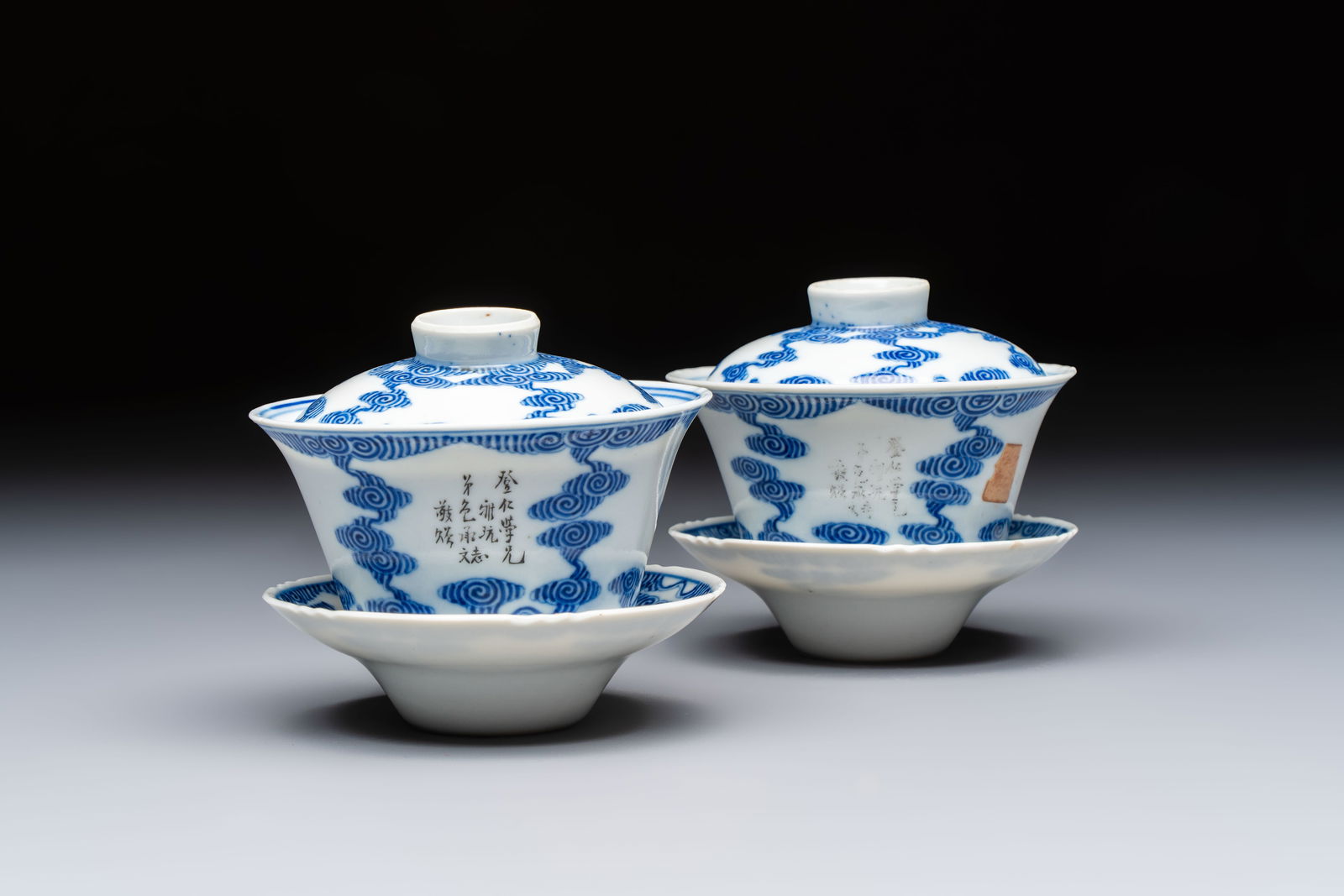 A pair of Chinese inscribed blue and white 'Clouds' tea bowls, covers and stands, Guangxu mark and (1 of 12)
