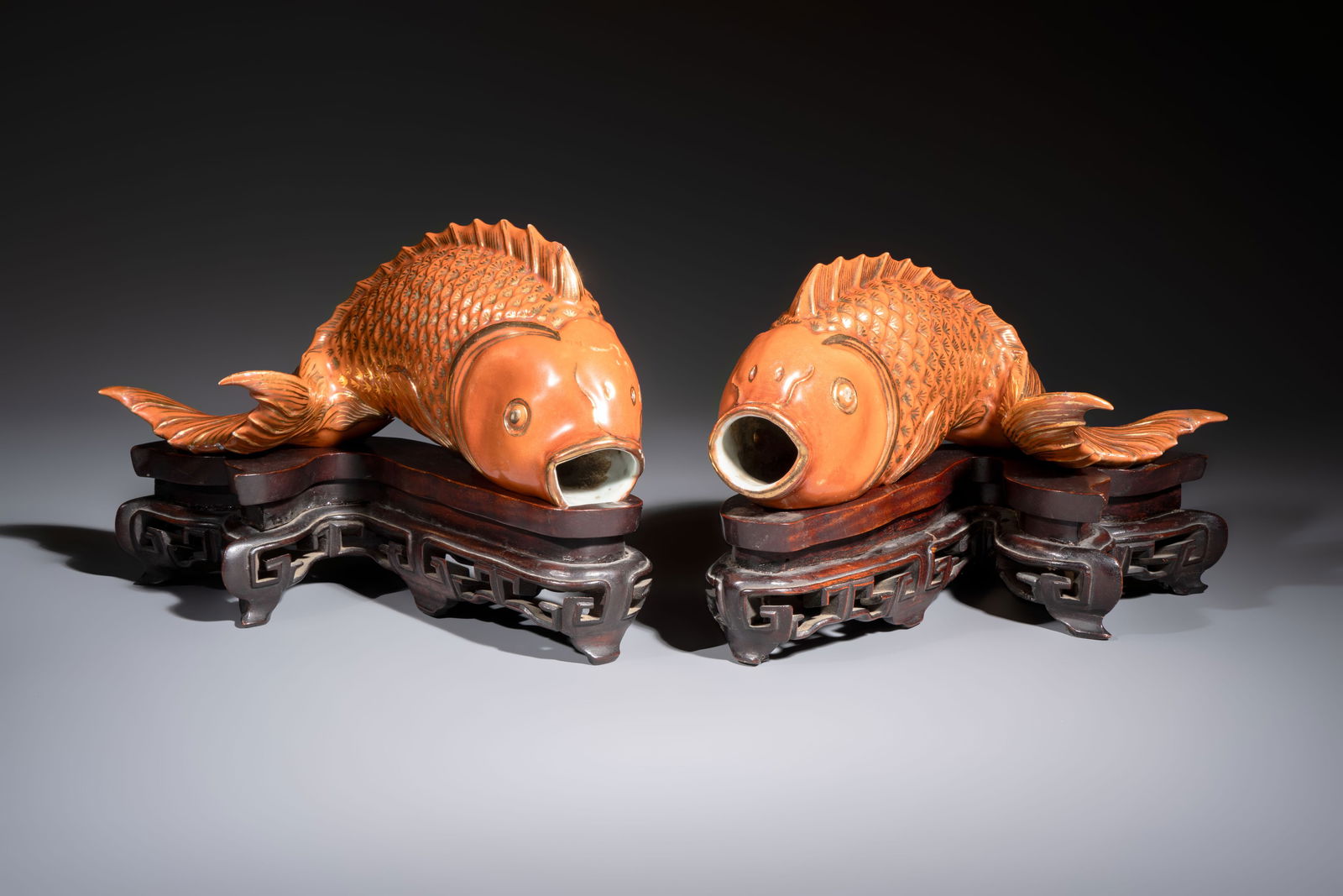 A pair of Chinese coral-red-glazed gilt-decorated 'Goldfish' wall pocket vases on wooden stands, (1 of 8)