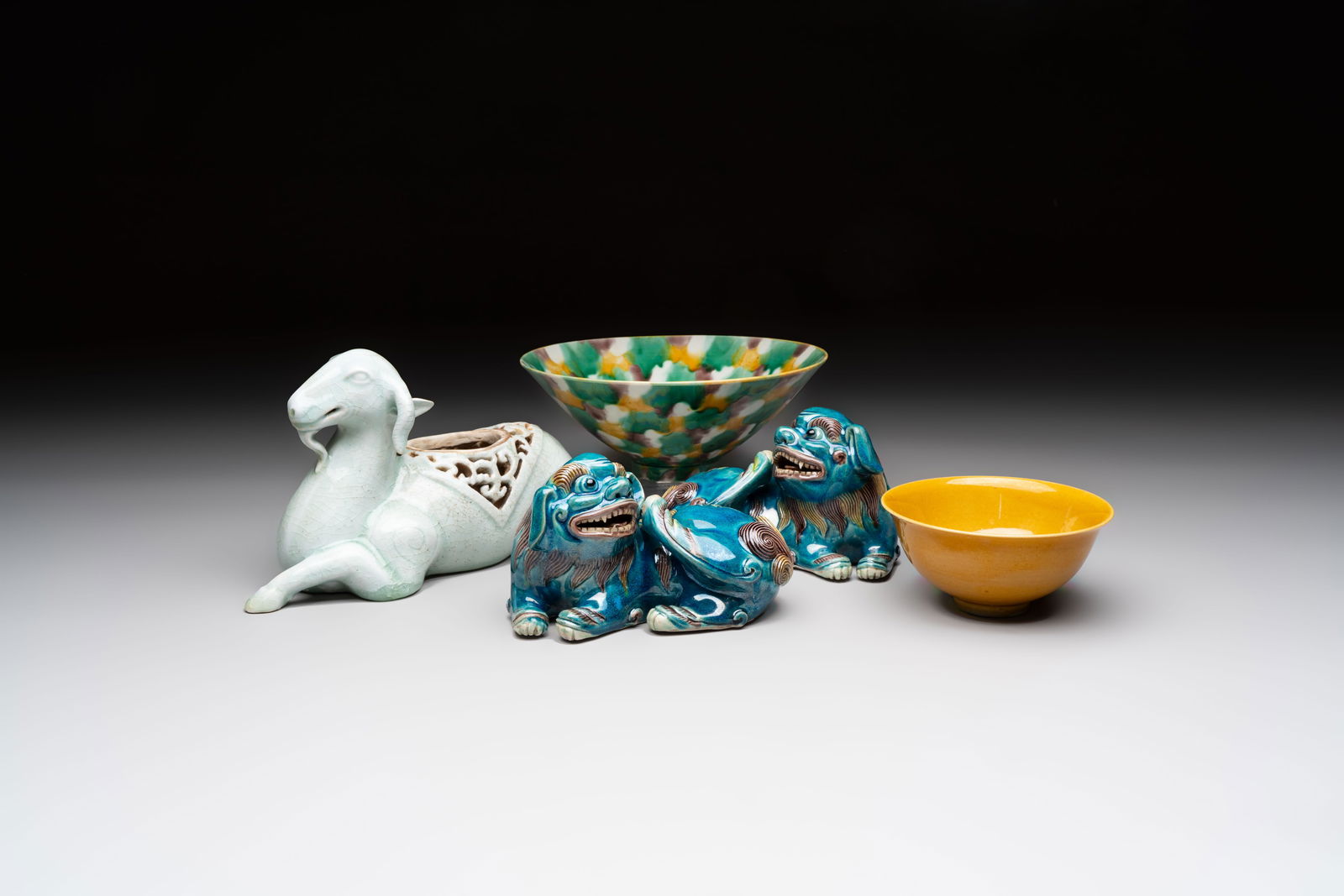 A pair of Chinese polychrome lions, a celadon-glazed goat, a yellow-glazed bowl and a sancai-glazed (1 of 20)