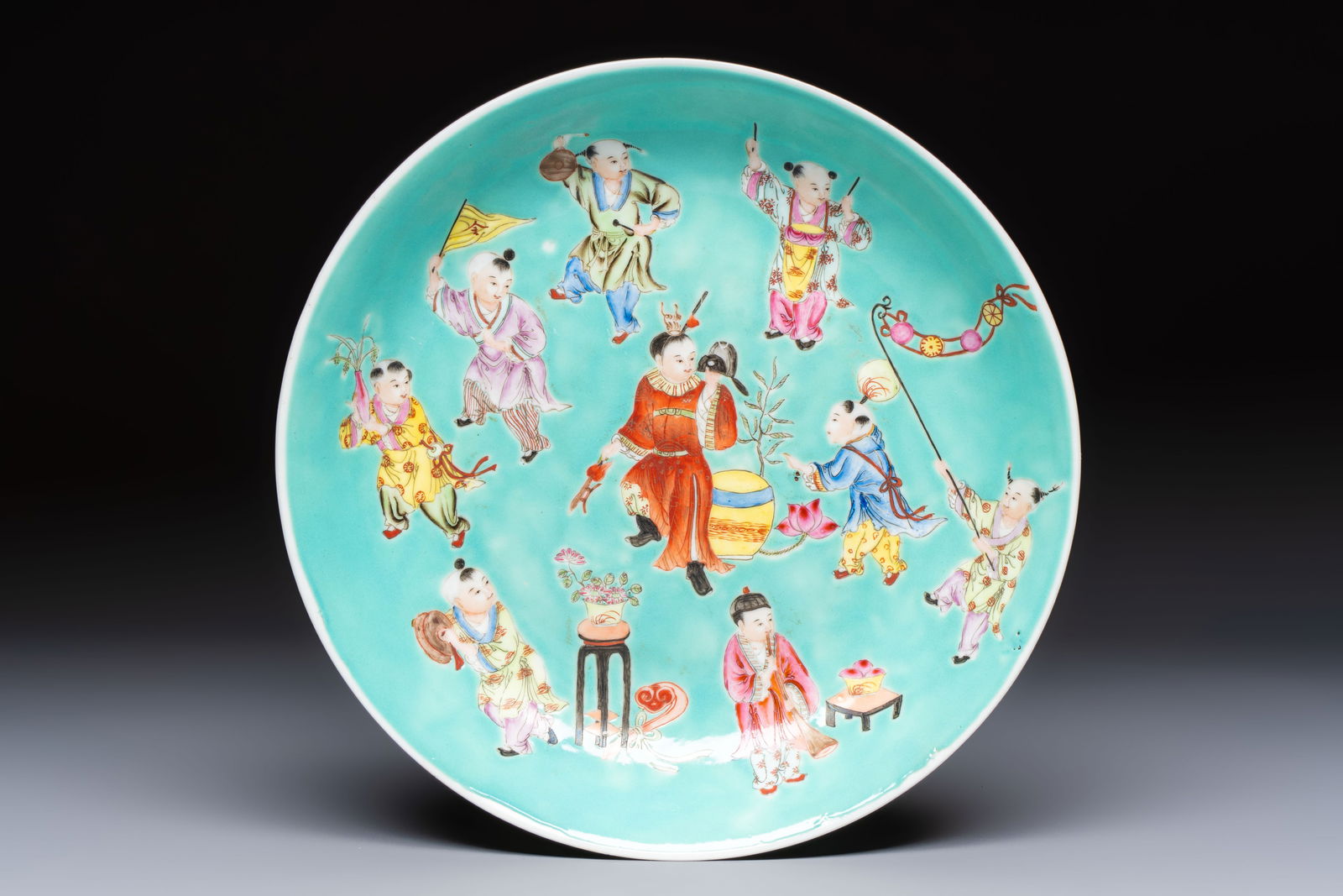 A Chinese famille rose turquoise-ground 'Playing Boys' plate, Qianlong mark, Republic (1 of 2)
