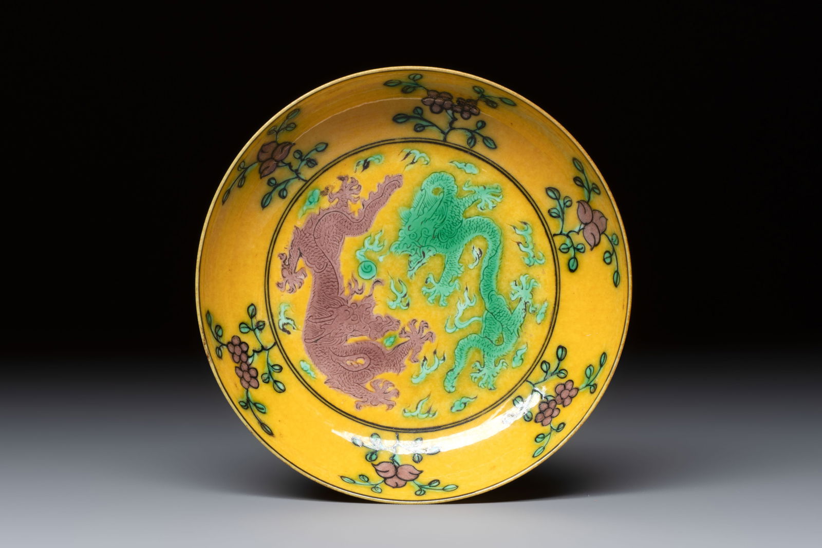 A small Chinese yellow-ground aubergine and green enamelled dragon plate, Qianlong mark, 19/20th C. (1 of 2)