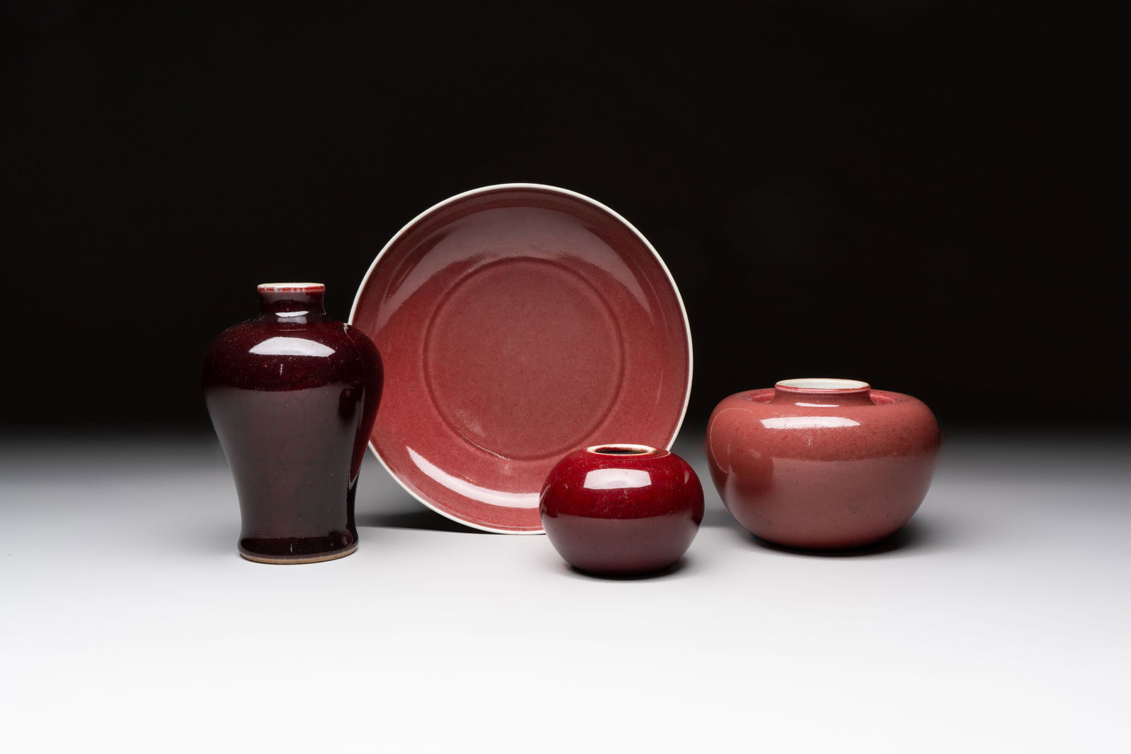 A Chinese copper-red-glazed plate, a meiping vase and two water pots, Kangxi marks, 19/20th C. (1 of 13)