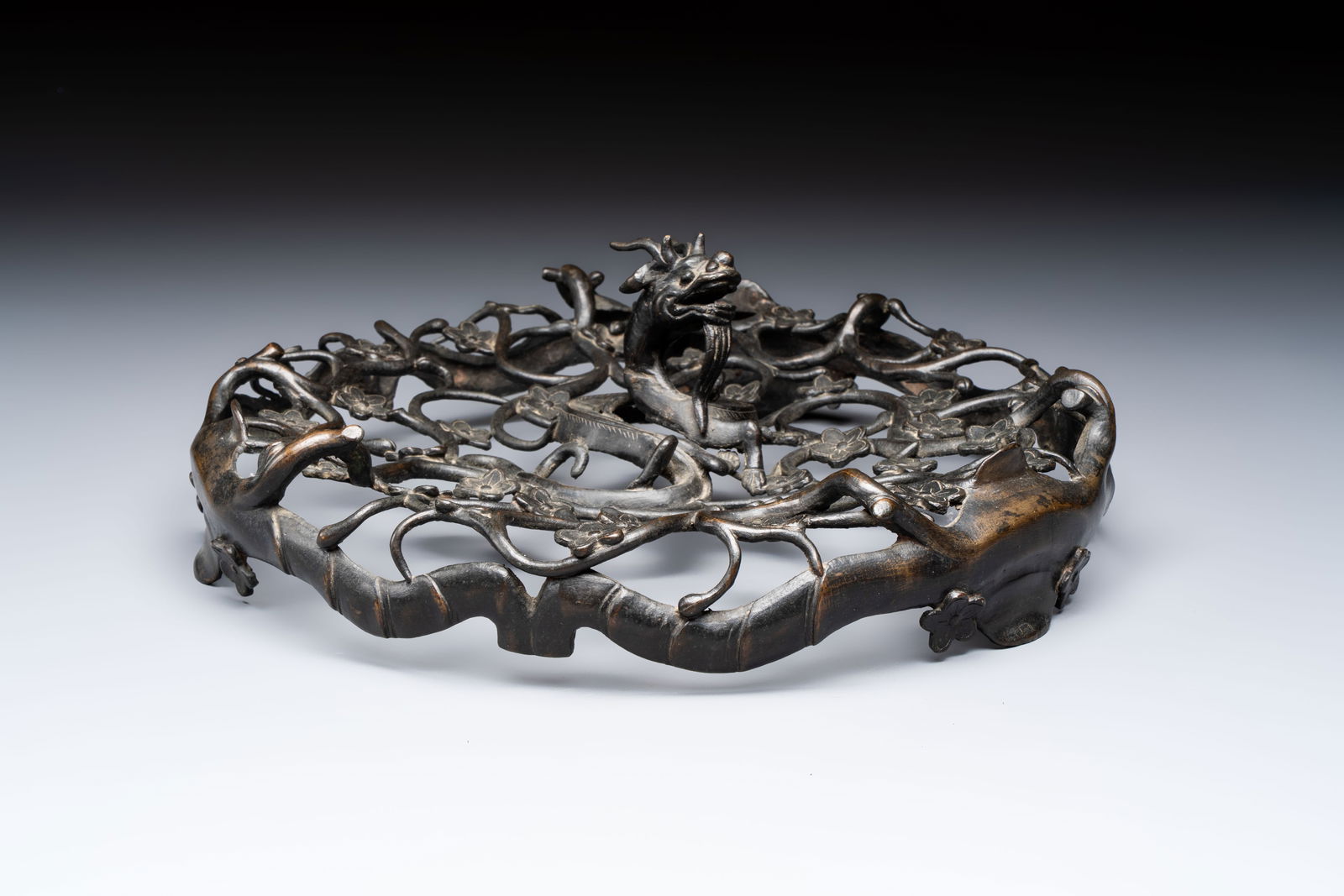 A large Chinese archaistic bronze 'Dragon' stand, Ming: A large Chinese archaistic bronze 'Dragon' stand, Ming Dia.: 33 cm - H.: 11,2 cm Weight: 2,3 kilograms