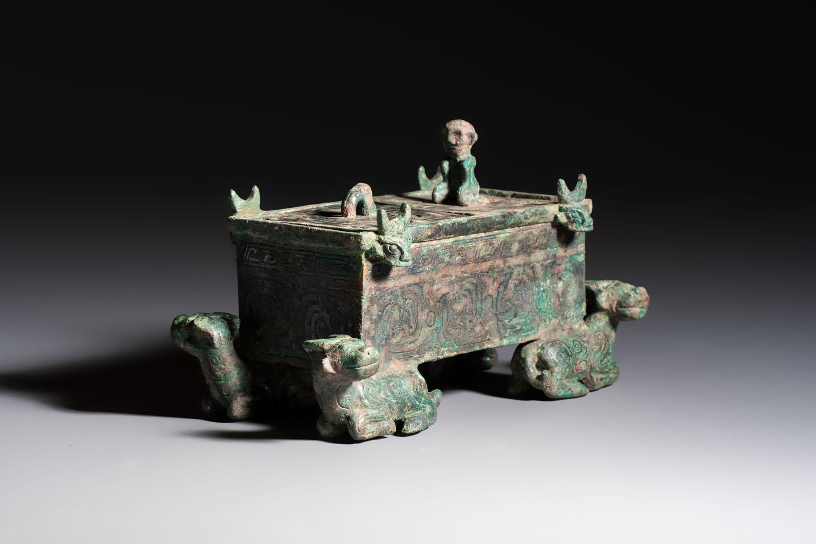A Chinese archaic bronze cosmetic box standing on four stylised buffalo-form feet, Lian, Eastern (1 of 9)