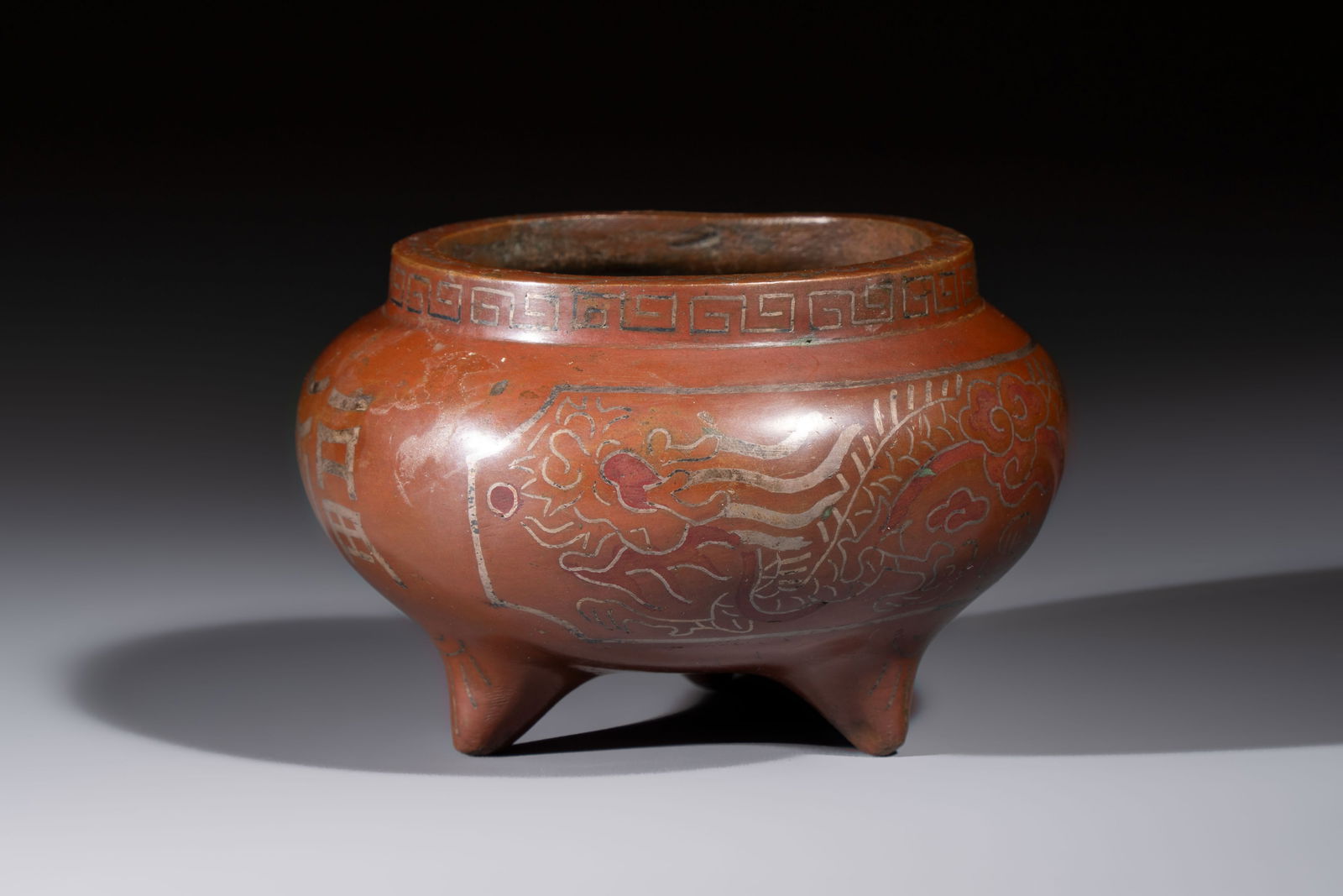 A Chinese or Vietnamese silver-inlaid bronze 'Fu Lu Shou' tripod censer, Xuande mark, 19th C.: A Chinese or Vietnamese silver-inlaid bronze 'Fu Lu Shou' tripod censer, Xuande mark, 19th C. Dia.: 11,5 cm - H.: 7,1 cm Weight: 935 grams