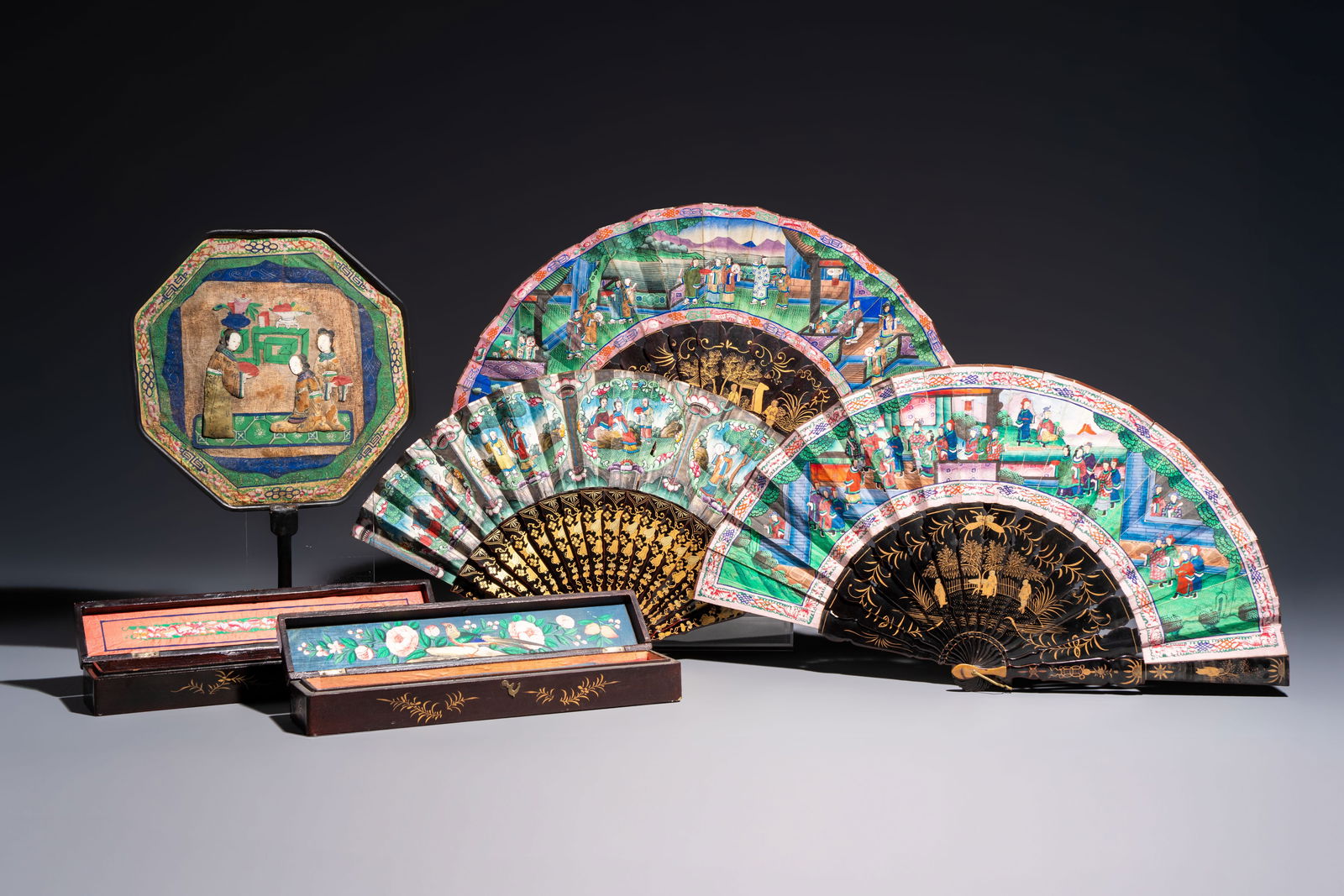 Three Chinese Canton gilt-lacquered and painted paper fans, two with their original box, and an: Three Chinese Canton gilt-lacquered and painted paper fans, two with their original box, and an octagonal fan, 19th C. Dim.: 51 x 27,8 cm (the folding fans, opened) Dim.: 31,9 x 5,9 x 4,7 cm (the boxe
