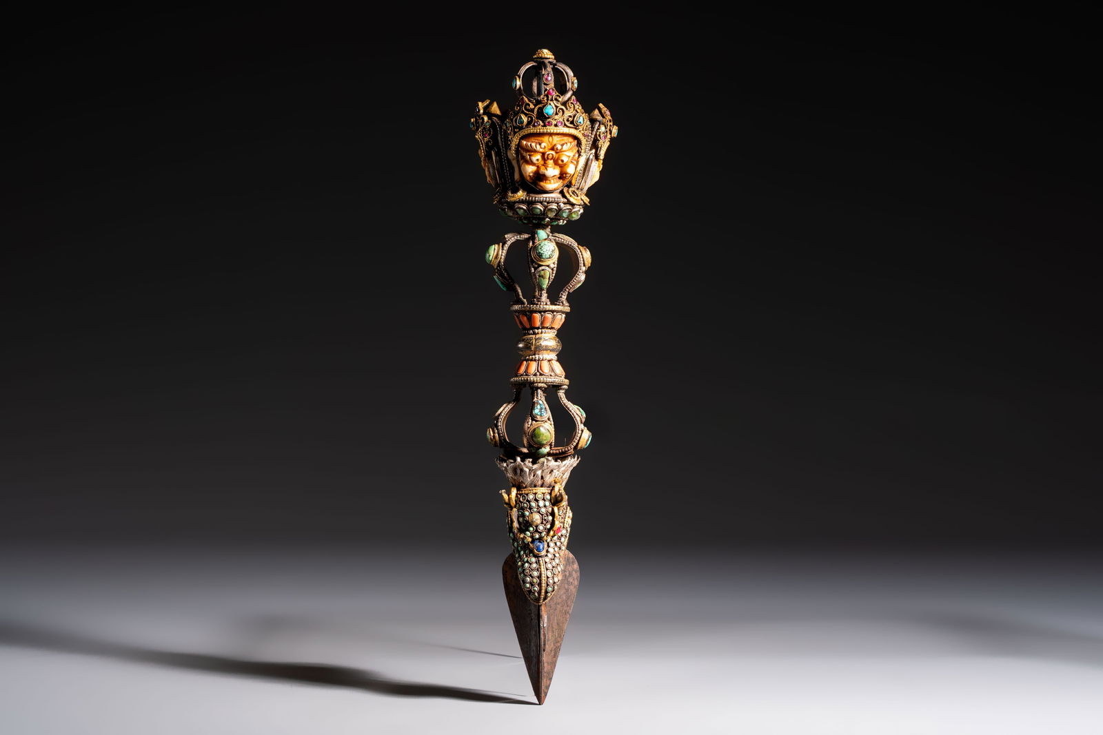 A Tibetan parcel-gilt silver and iron phurba inlaid with precious stones, red coral and bone, 19th (1 of 6)