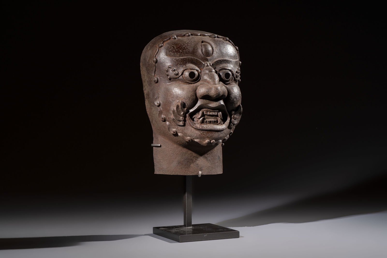 A Tibetan cast iron 'Mahakala' mask, 18/19th C. (1 of 7)