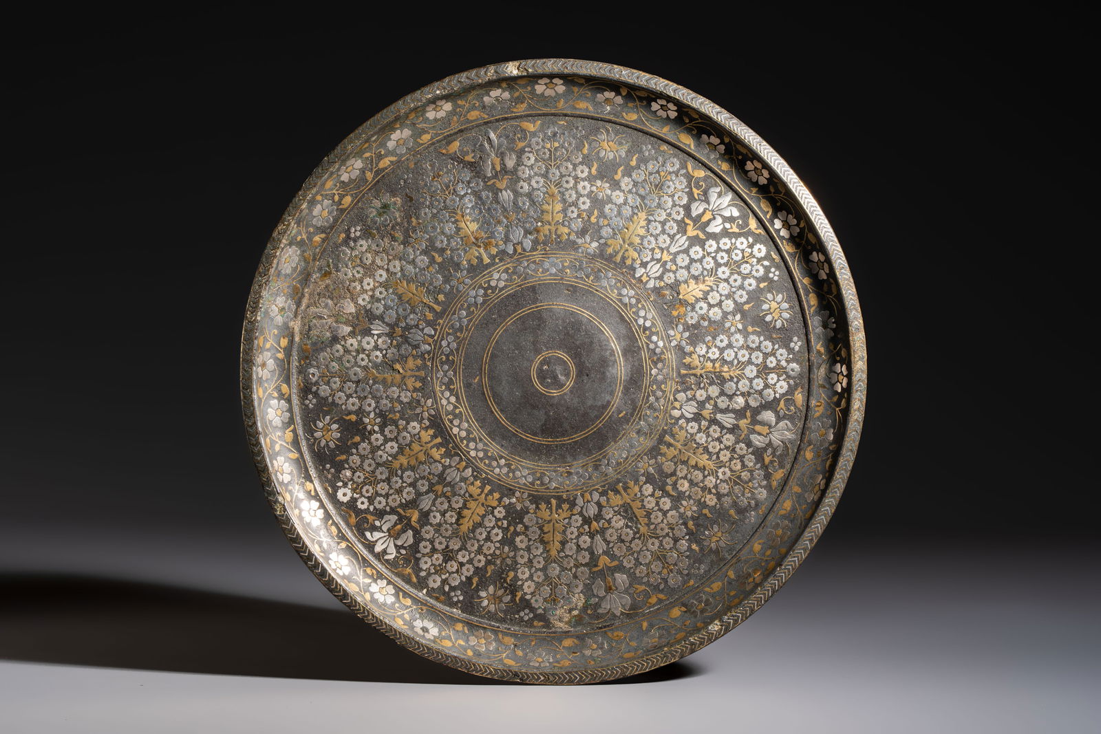 A fine Mughal silver- and brass-inlaid metal alloy Bidri tray, Bidar, Deccan, India, 17th C.: A fine Mughal silver- and brass-inlaid metal alloy Bidri tray, Bidar, Deccan, India, 17th C. Dia.: 32 cm Weight: 1887 grams