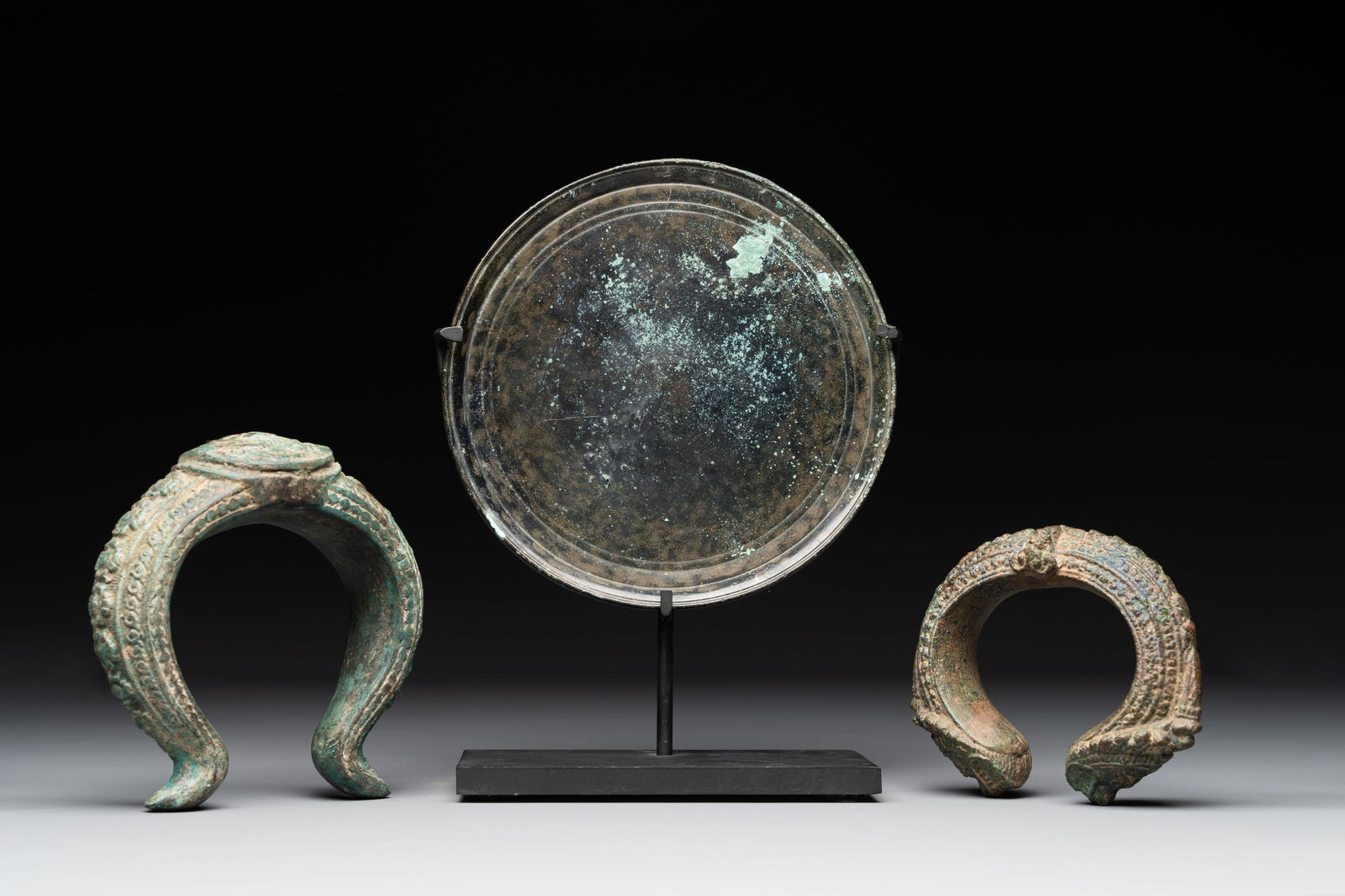 A bronze mirror, a bracelet with a royal or noble emblem and a bronze bracelet with two tiger heads, (1 of 10)