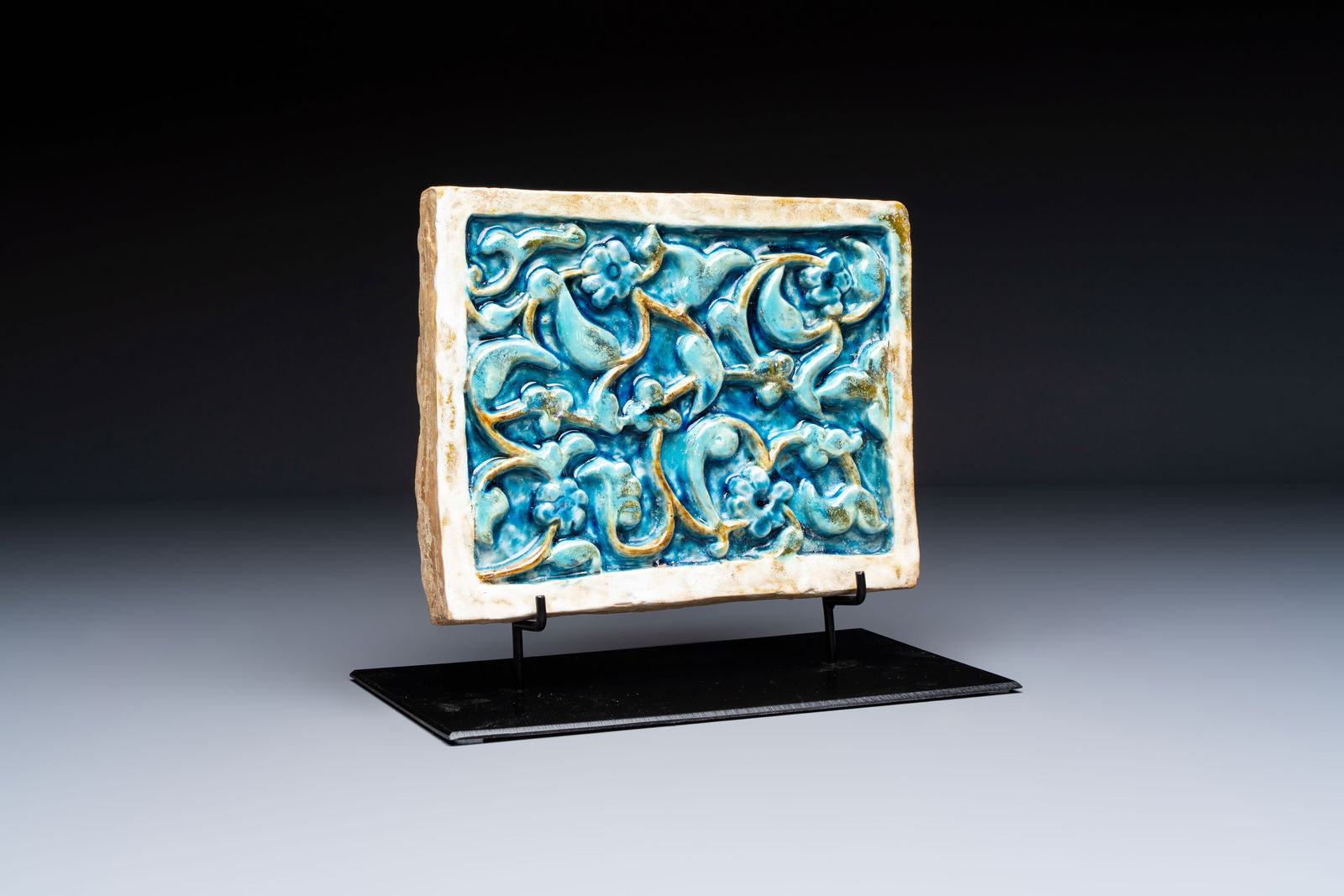 A Timurid polychrome-glazed rectangular tile with foliage design, on a later metal stand, Central (1 of 5)
