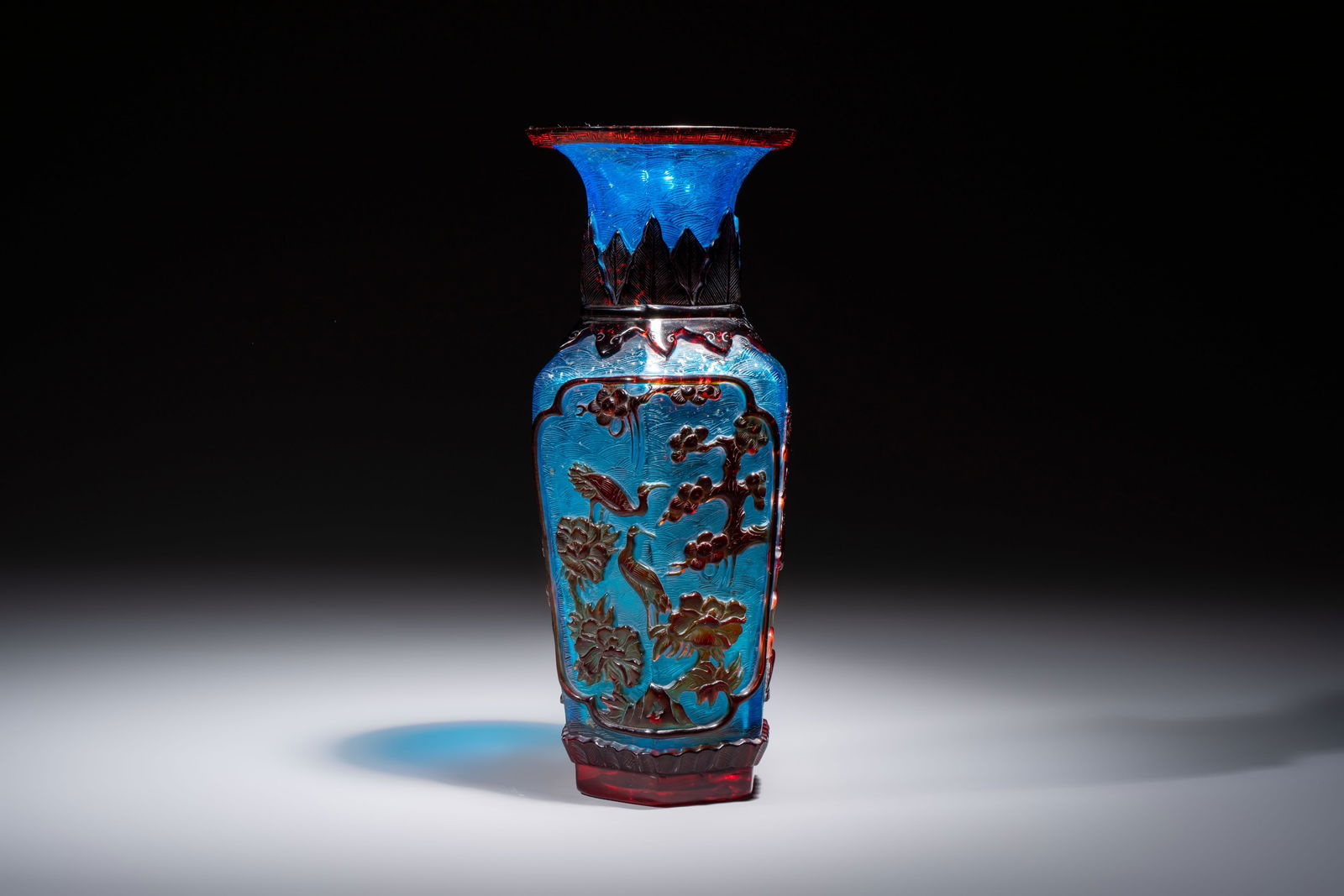 A Chinese red-overlay blue glass 'Cranes' hexagonal vase, Qianlong mark and of the period: A Chinese red-overlay blue glass 'Cranes' hexagonal vase, Qianlong mark and of the period H.: 25,5 cm