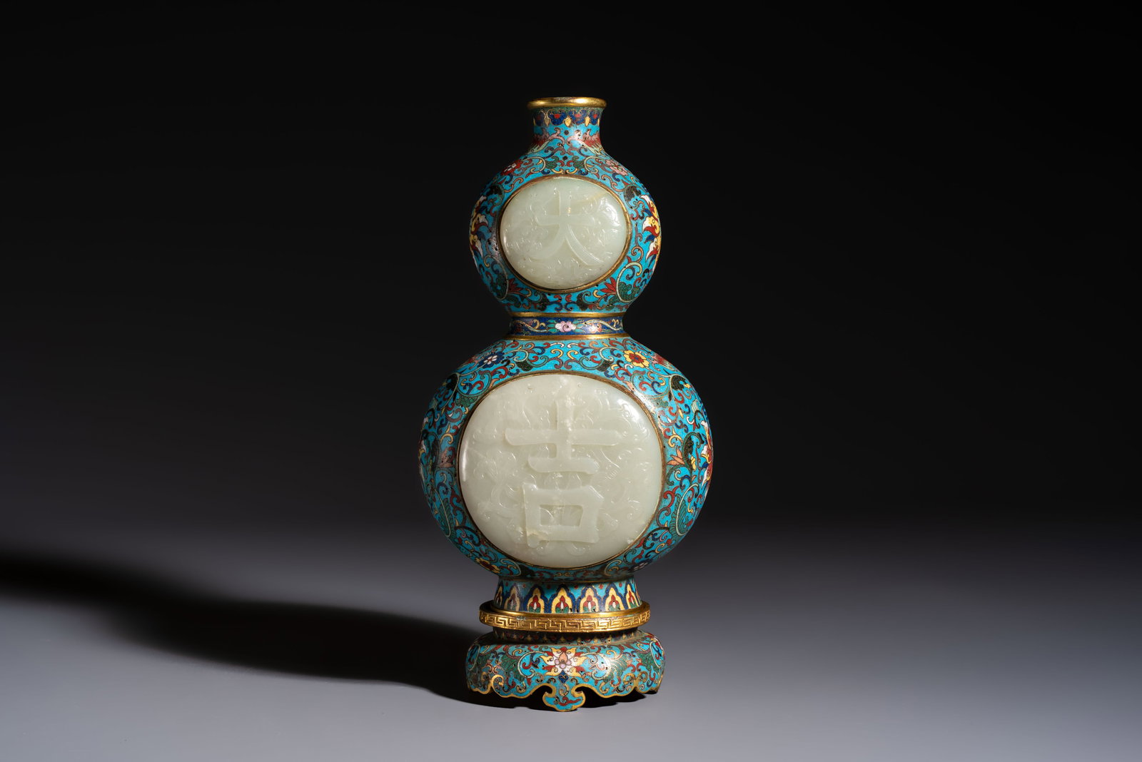 A Chinese cloisonné and jade 'Da Ji and Tian Xi' double-gourd vase and stand , 19/20th C.: A Chinese cloisonné and jade 'Da Ji and Tian Xi' double-gourd vase and stand , 19/20th C. H.: 27 cm (incl. stand) H.: 23,2 cm (excl. stand)