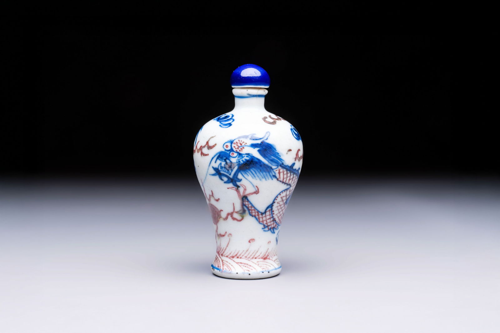 A Chinese blue, white and copper-red 'Dragon' snuff bottle, 19th C. (1 of 7)