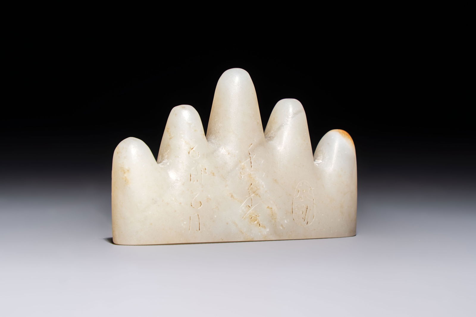 A Chinese white jade mountain-shaped brush rest with narcissus design, Dajie mark, dated 1879: A Chinese white jade mountain-shaped brush rest with narcissus design, Dajie mark, dated 1879 L.: 7,9 cm - H.: 4,8 cm Weight: 130 grams