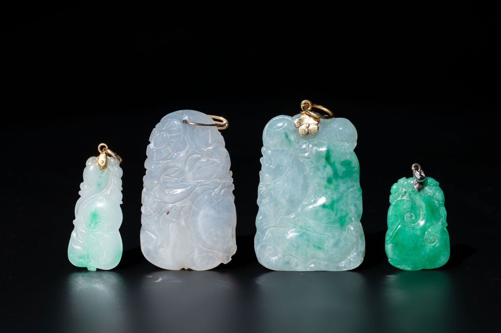 Four Chinese gold- and silver-mounted jadeite pendants, 19/20th C. (1 of 2)
