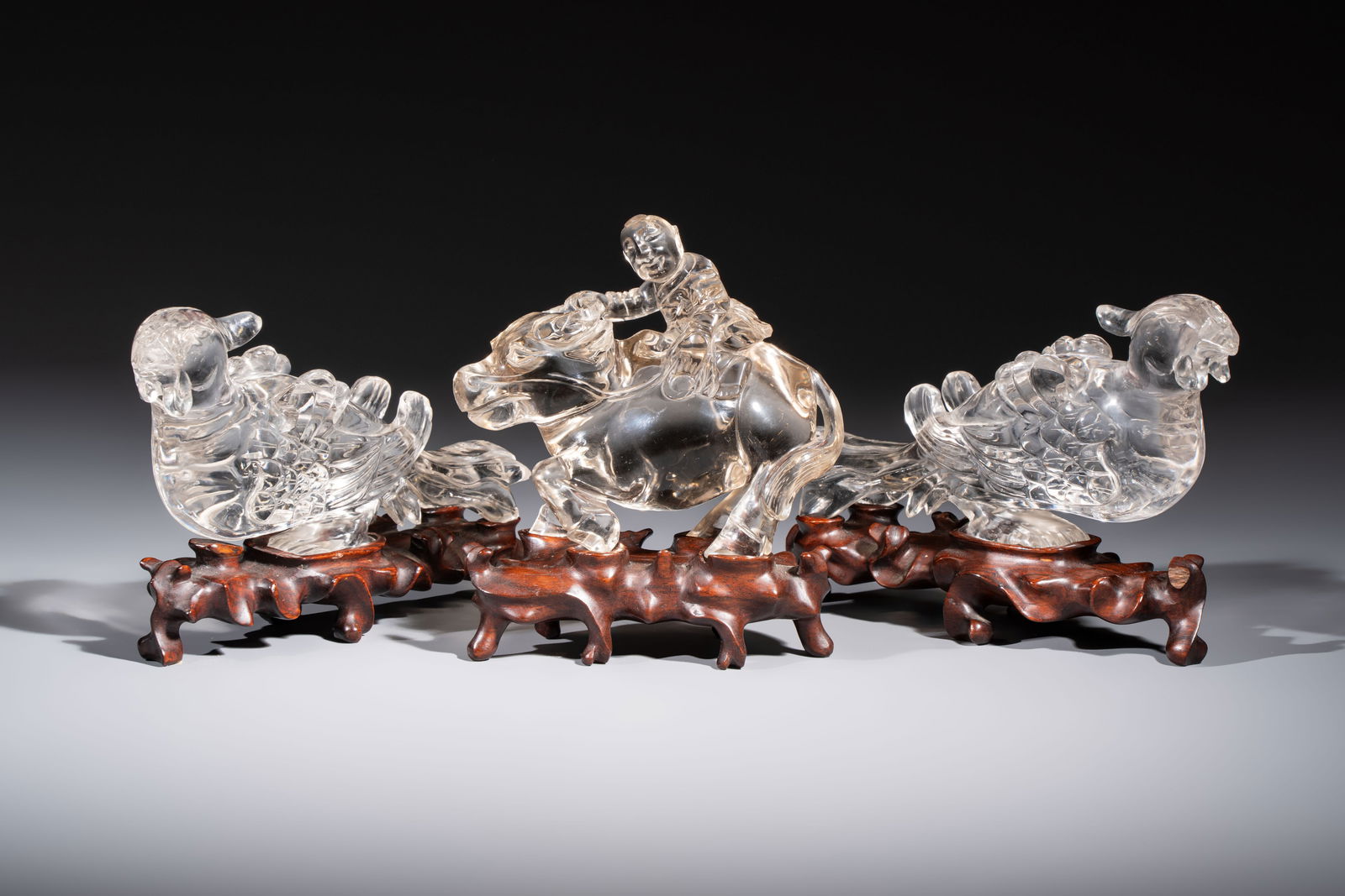 Three Chinese rock crystal sculptures on wooden stands, Republic: Three Chinese rock crystal sculptures on wooden stands, Republic H.: 14 cm (the buffalo and boy group incl. stand) H.: 10,5 cm (the buffalo and boy group excl. stand) H.: 11,8 cm (the birds incl. stan