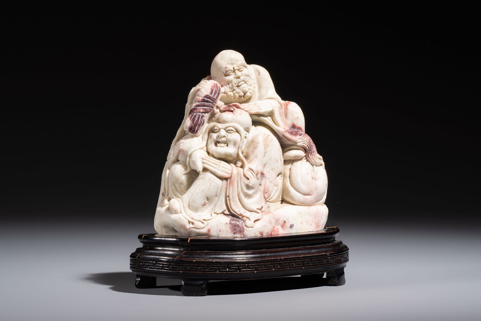 A Chinese stone group of 'Luohan' on wooden stand, Republic (1 of 7)