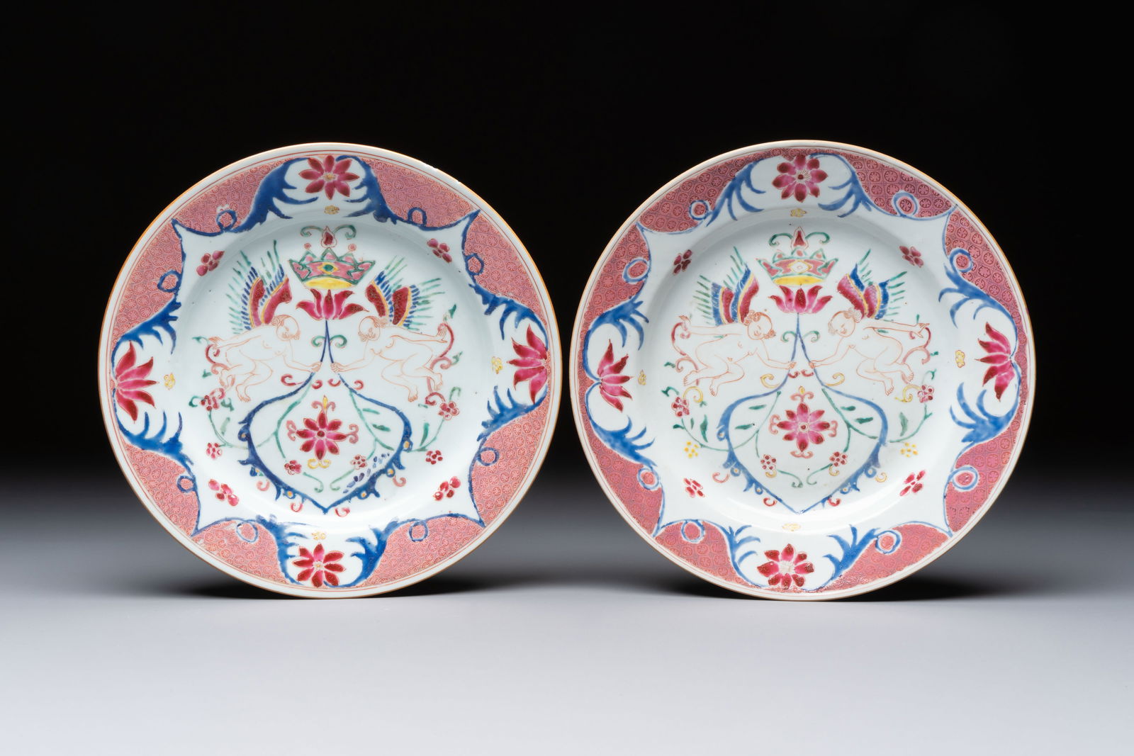 A pair of Chinese famille rose 'Winged Putti' plates, Yongzheng/Qianlong (1 of 2)