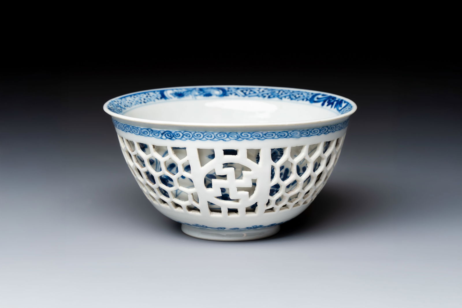 A Chinese blue and white reticulated double-walled 'Swastika' bowl, Kangxi (1 of 7)