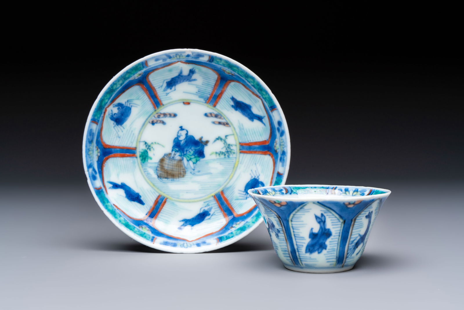 A Chinese European-decorated blue and white 'Fisherman' cup and saucer, Kangxi: A Chinese European-decorated blue and white 'Fisherman' cup and saucer, Kangxi Dia.: 10,3 cm (the saucer) Dia.: 6,5 cm - H.: 3,5 cm (the cup) Provenance: - The Geoffrey Middle Collection, UK.