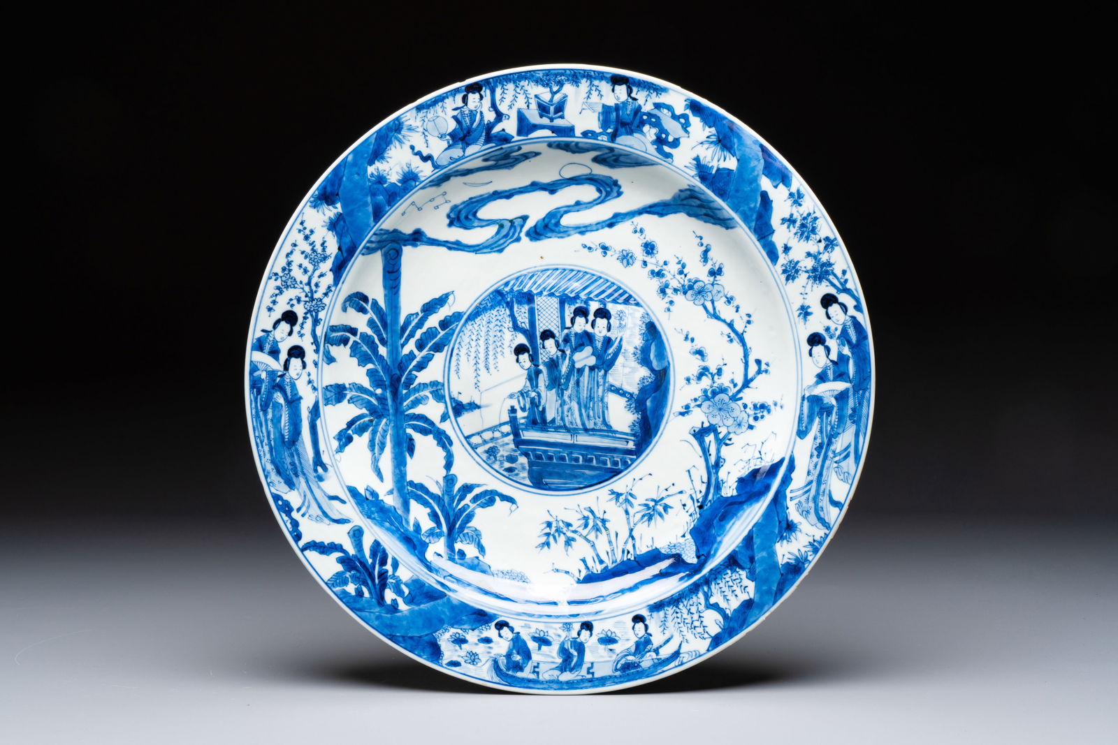 A fine Chinese blue and white 'Elegant Beauties' dish with raised central medallion, Kangxi (1 of 2)