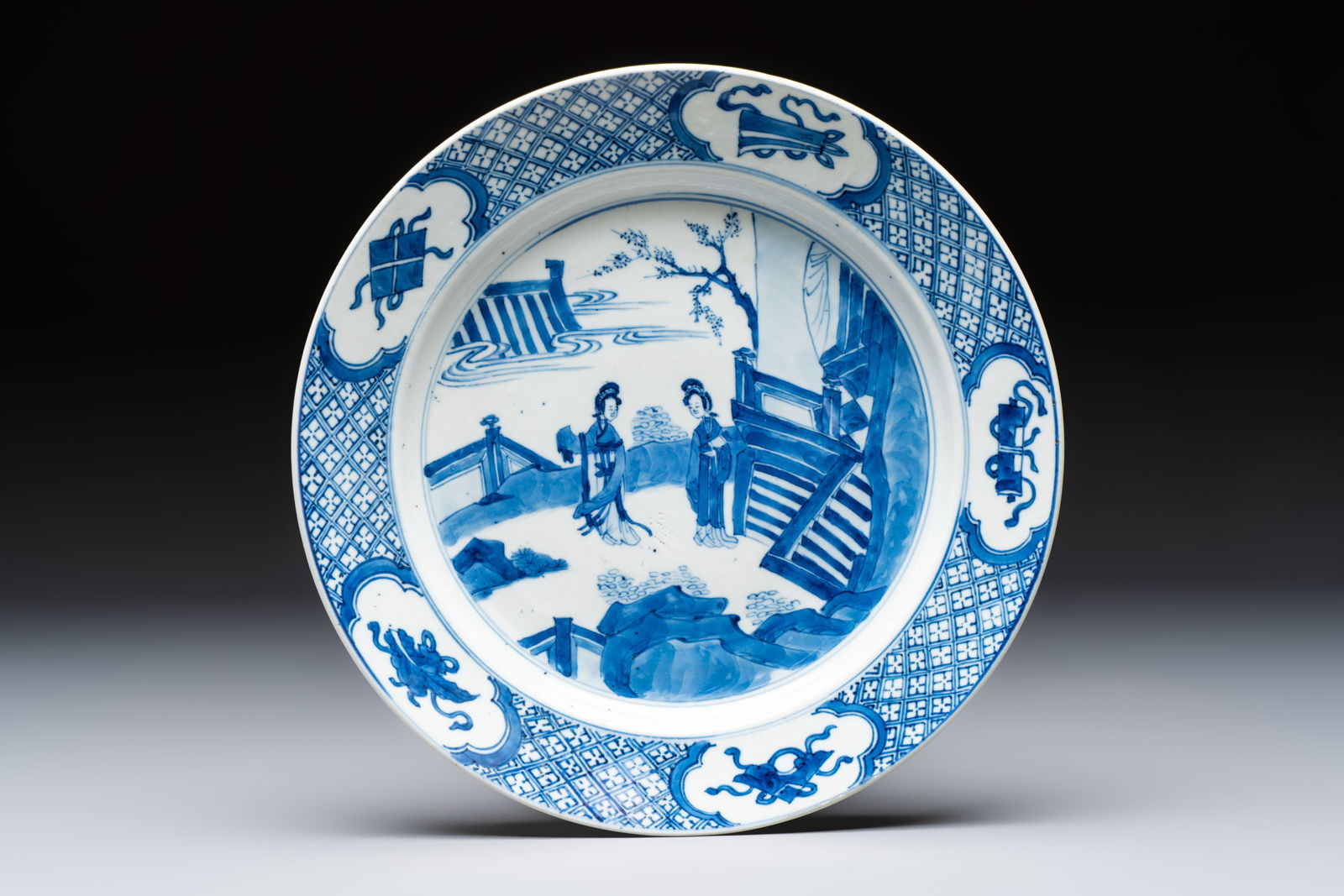 A Chinese blue and white 'Elegant Beauties' plate, Kangxi mark and of the period: A Chinese blue and white 'Elegant Beauties' plate, Kangxi mark and of the period Dia.: 27,2 cm