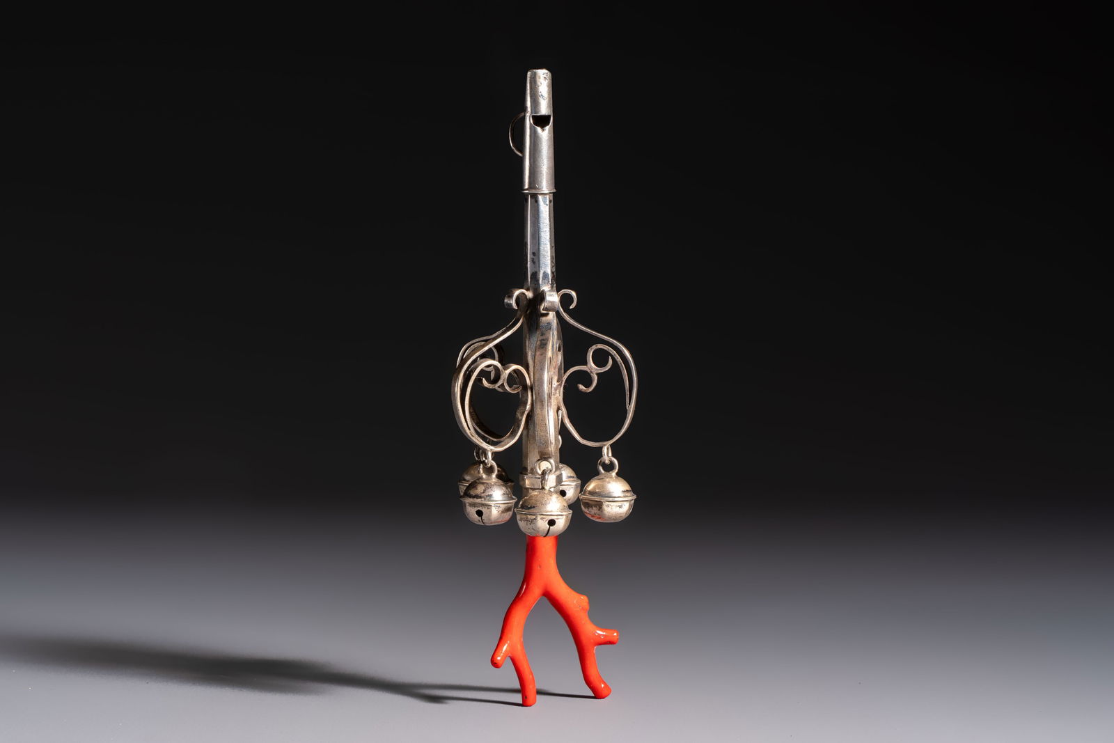A silver red coral-mounted children's rattle-whistle, 19th C. or earlier: A silver red coral-mounted children's rattle-whistle, 19th C. or earlier L.: 16 cm Weight: 46 grams