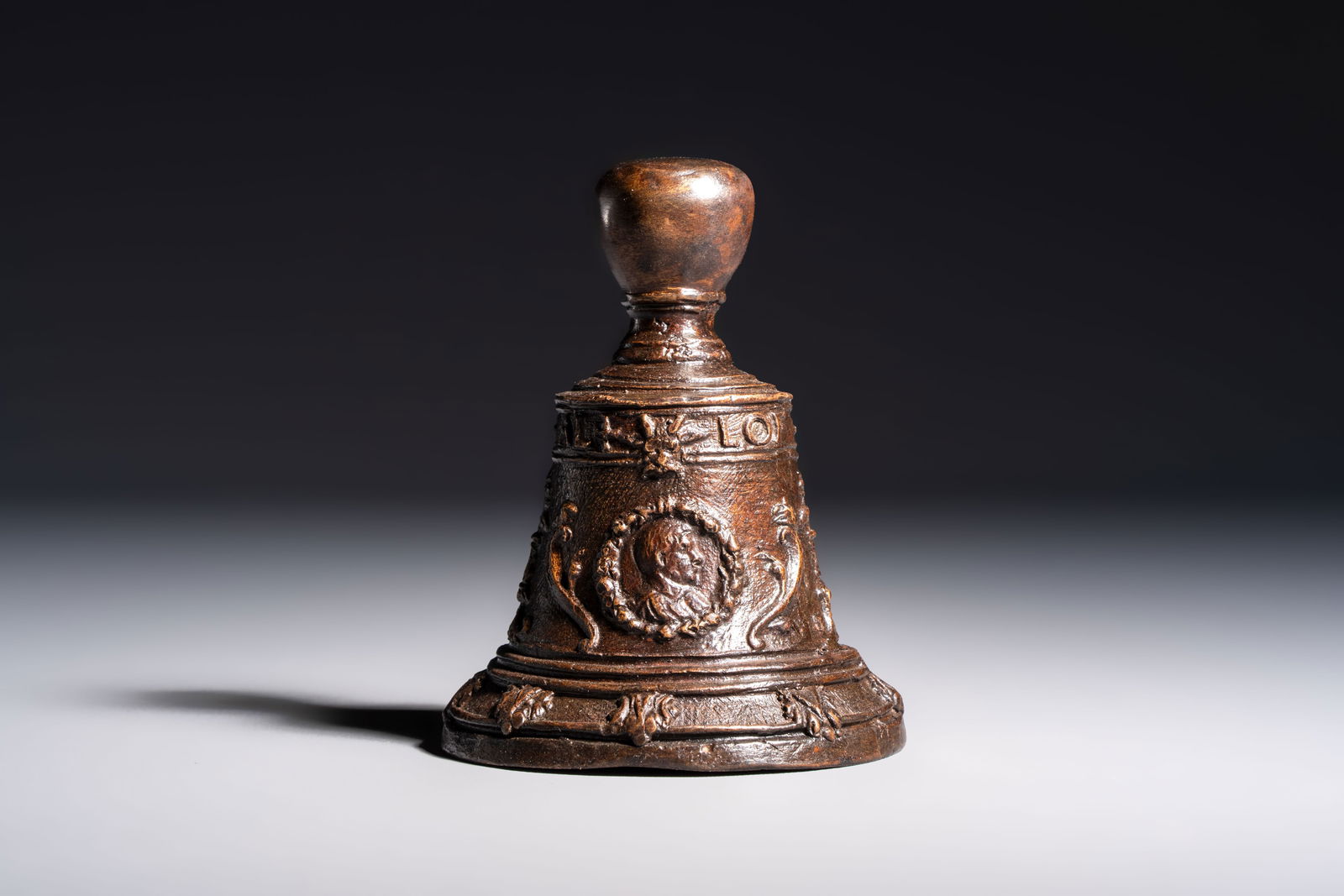 A cast bronze table bell, inscribed 'Lof God van Al', The Netherlands, 17/18th C. (1 of 6)