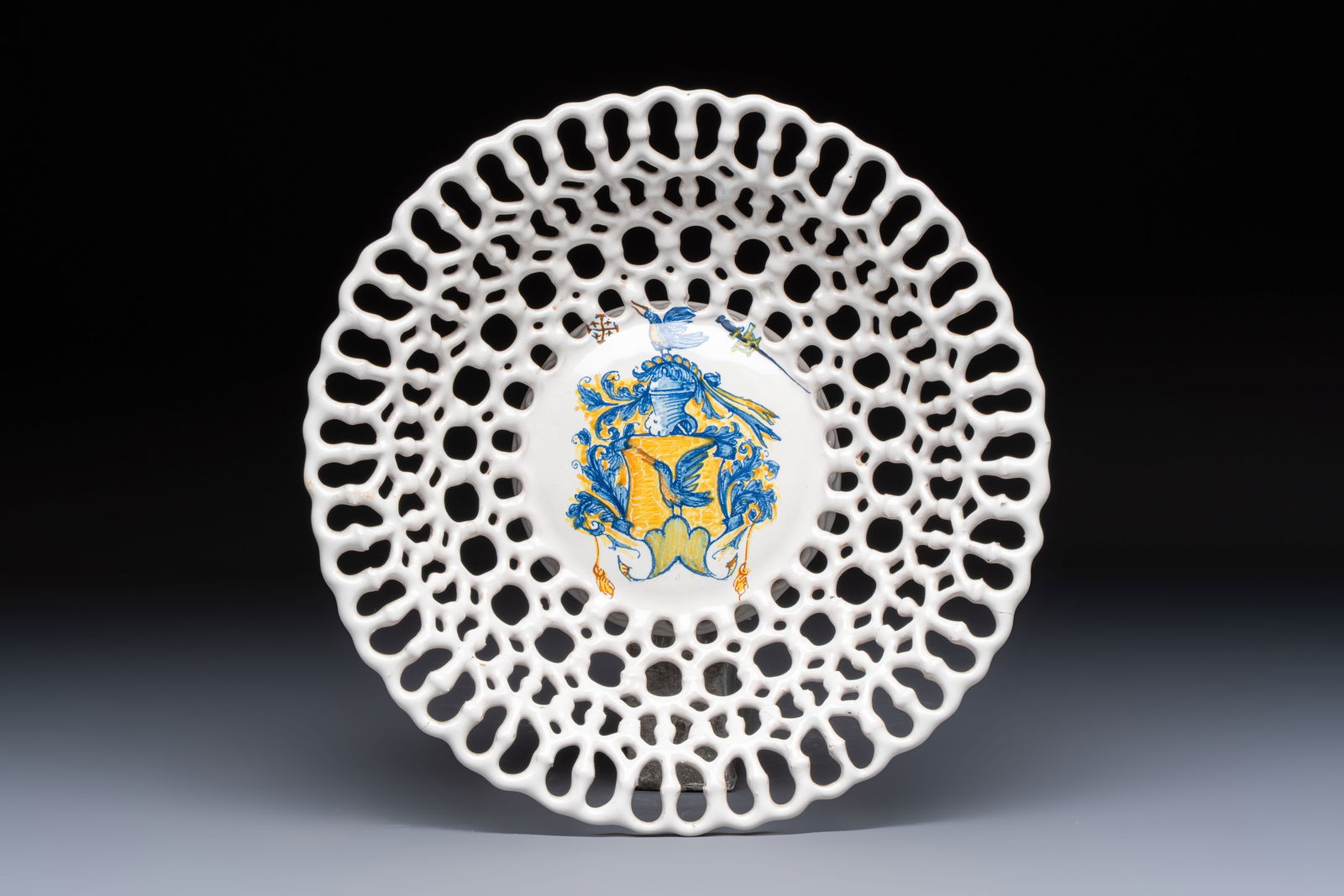 A polychrome Italian maiolica armorial reticulated basket, workshop of Virgiliotto Calamelli,: A polychrome Italian maiolica armorial reticulated basket, workshop of Virgiliotto Calamelli, Faenza, 16th C. Dia.: 25,8 cm - H.: 7,5 cm Ref.: - The Victoria and Albert Museum, London, accession numbe