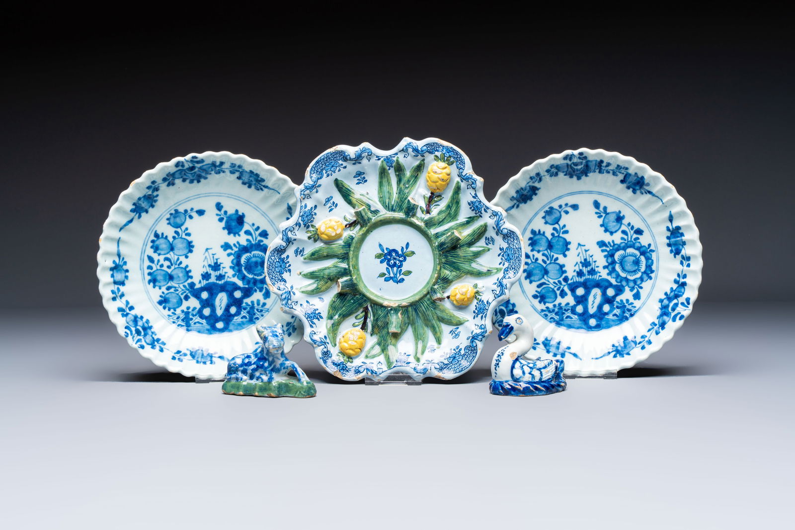 Two polychrome Dutch Delft miniature models of animals, a 'Pineapple' stand and a pair of blue and: Two polychrome Dutch Delft miniature models of animals, a 'Pineapple' stand and a pair of blue and white plates, 18th C. Dia.: 19,5 cm (the pineapple stand) Dia.: 17 cm (the plates) H.: 5,8 cm (the ta