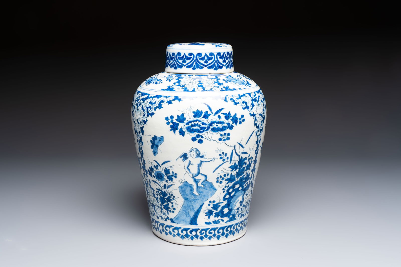 A refined blue and white Dutch Delft jar and cover with a putto on a rock, late 17th C.: A refined blue and white Dutch Delft jar and cover with a putto on a rock, late 17th C. H.: 34 cm