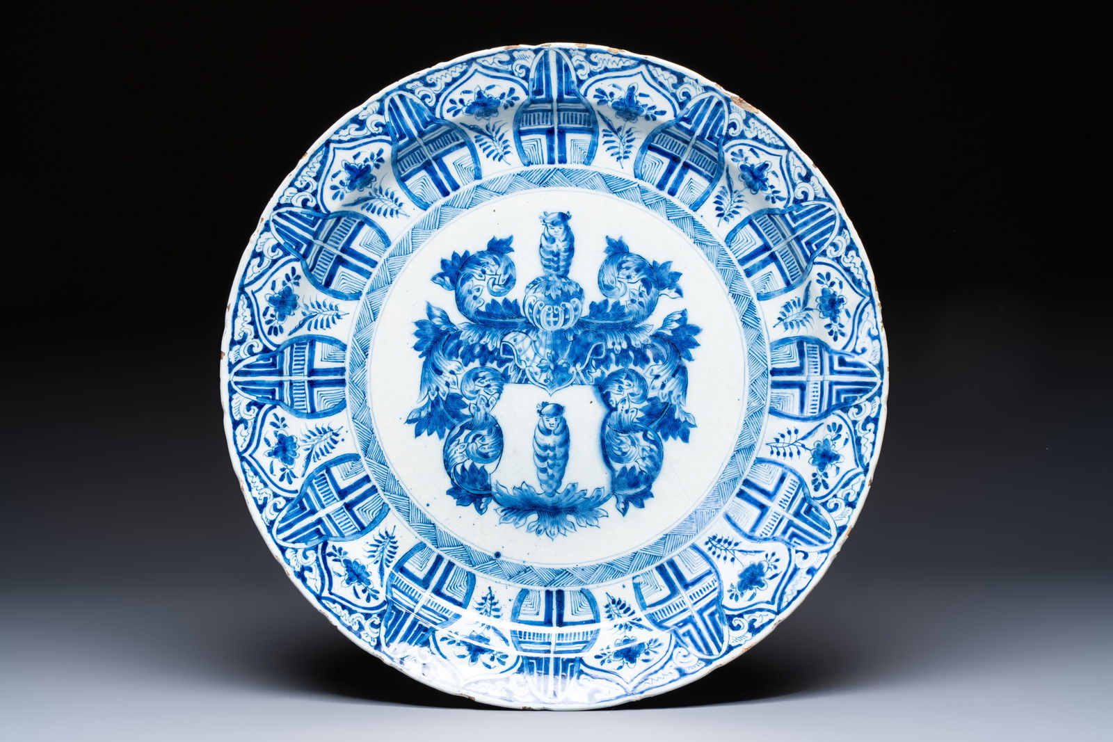 A large blue and white Dutch Delft armorial dish, 18th C.: A large blue and white Dutch Delft armorial dish, 18th C. Dia.: 39,6 cm Marked with a star for the "De Witte Starre" (The White Star) workshop, active 1660-1804.