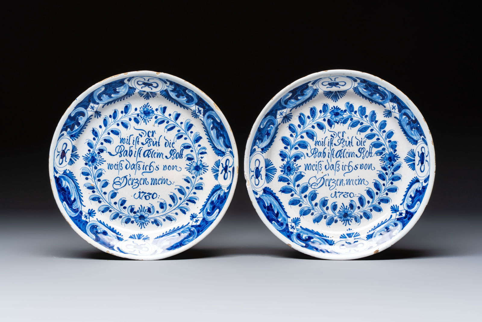 A pair of blue and white Delftware 'Proverb' plates, Germany, dated 1720 (1 of 2)