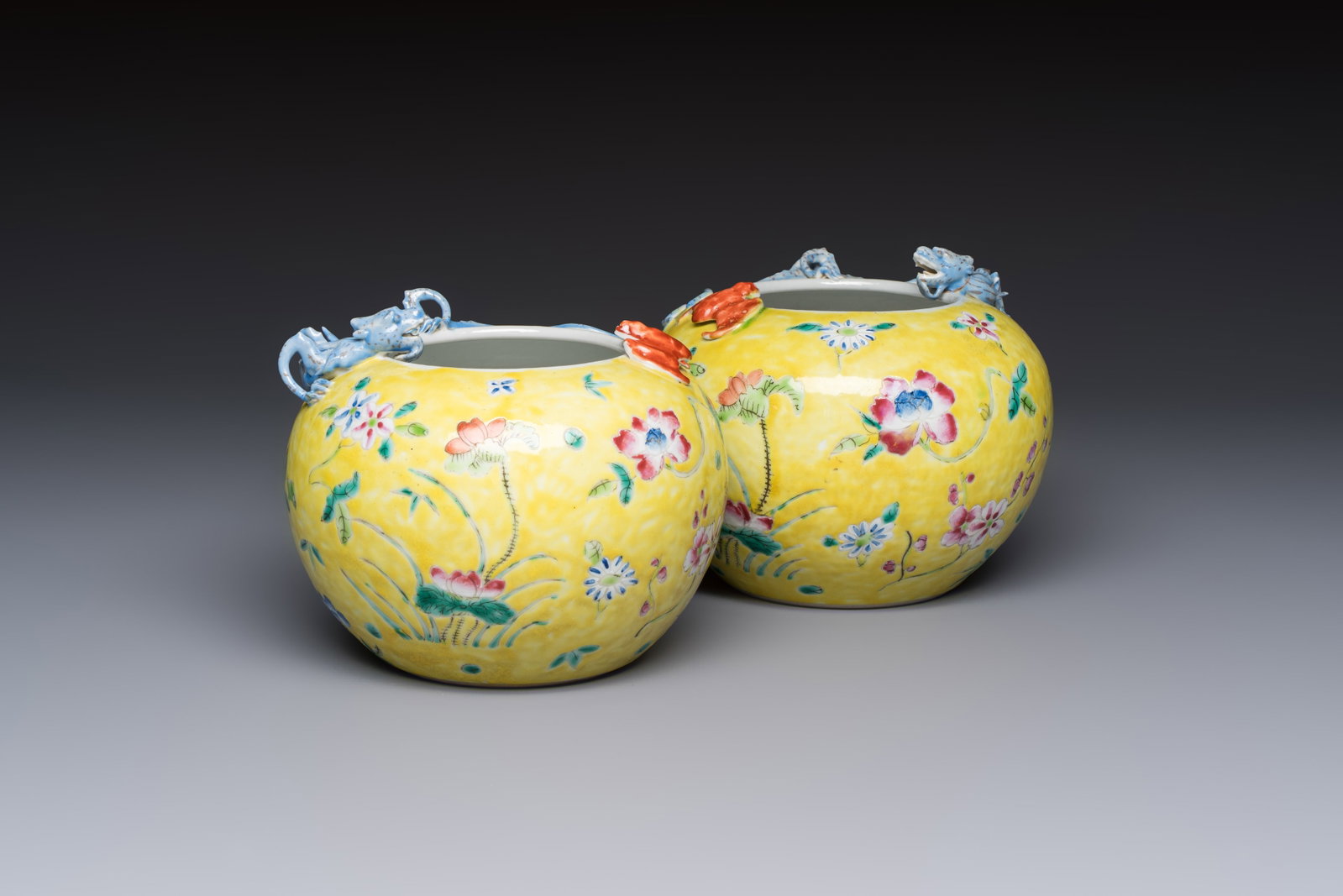 A pair of Chinese famille rose yellow-ground water pots with floral design and applied chilong and: A pair of Chinese famille rose yellow-ground water pots with floral design and applied chilong and bats, Qianlong mark, 19/20th C. H.: 12,2 cm