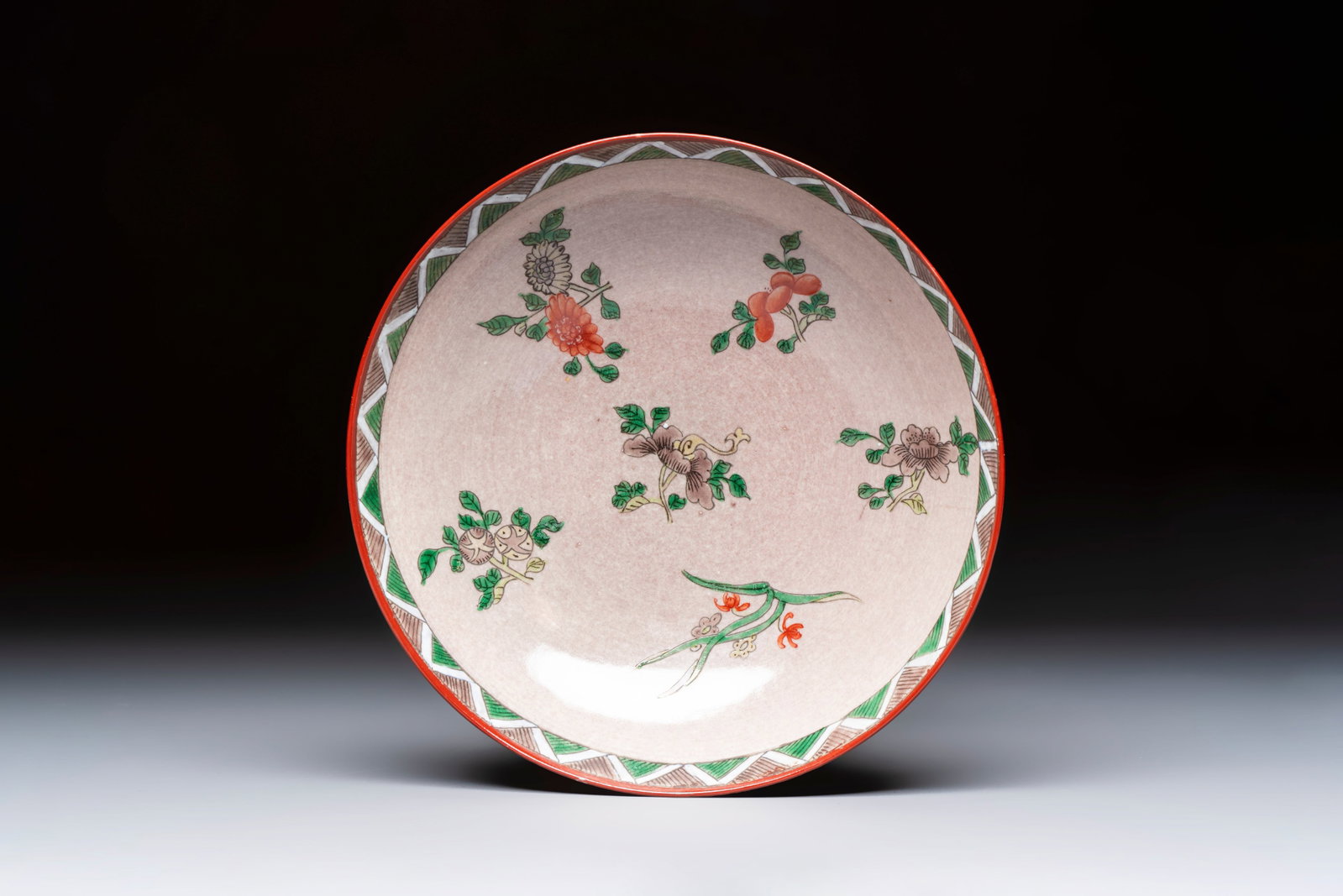 An unusual Chinese famille verte copper-red-ground shallow bowl with floral design, 19th C. (1 of 3)