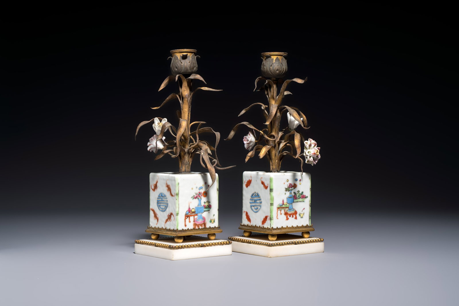 A pair of gilt silver and metal candlesticks with Chinese porcelain, European porcelain flowers, and: A pair of gilt silver and metal candlesticks with Chinese porcelain, European porcelain flowers, and marble bases, marked Boin-Taburet, late 19th C. Dim.: 7 x7 x 21 cm Both candlesticks bear stamped m