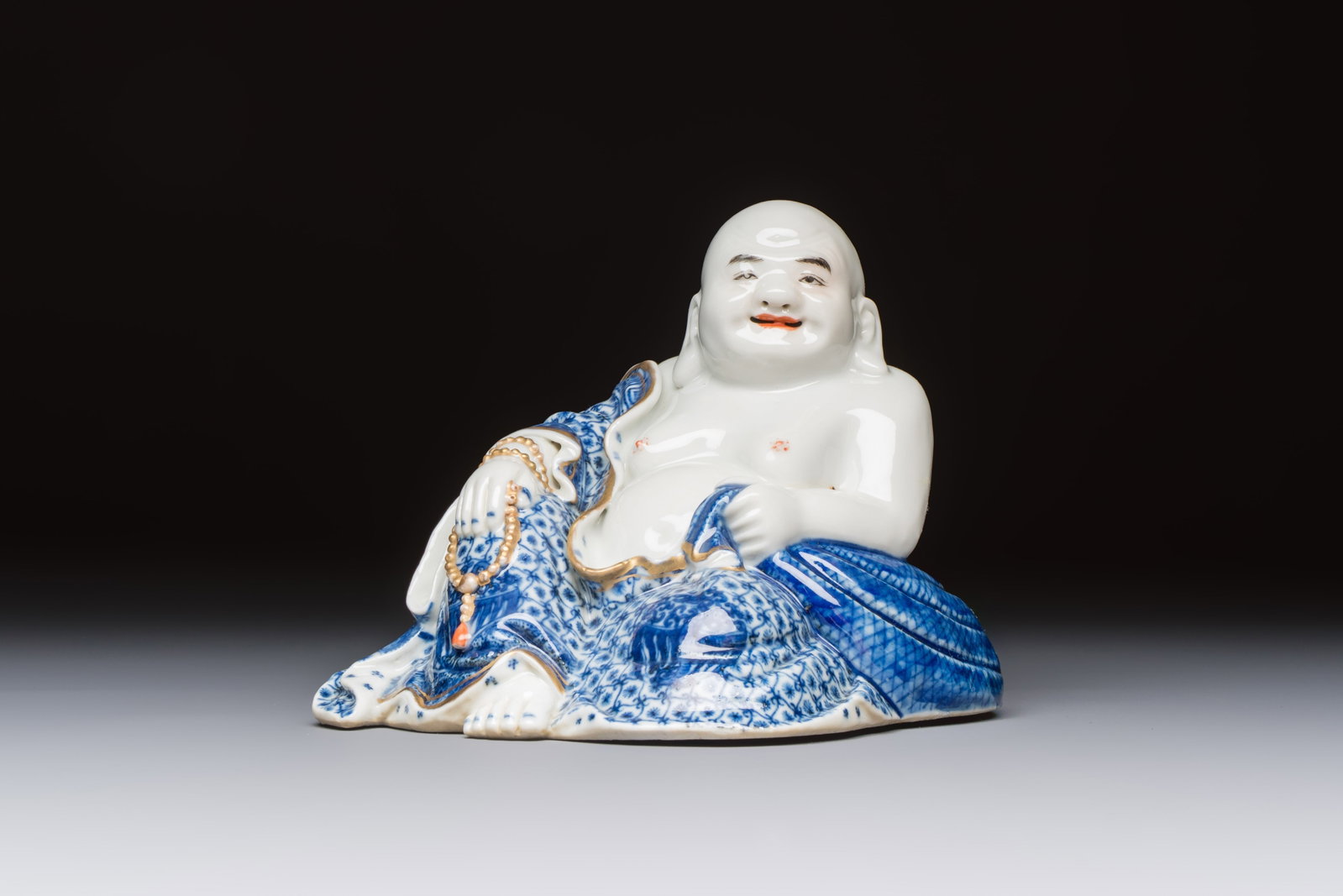 A Chinese blue and white, iron-red and gilt-decorated Milefo Buddha, Fu Jian Hui Guan: A Chinese blue and white, iron-red and gilt-decorated Milefo Buddha, Fu Jian Hui Guan and You Lin Ji Zhi marks, 20th C. Dim.: 13,5 x 13 x 12,4 cm