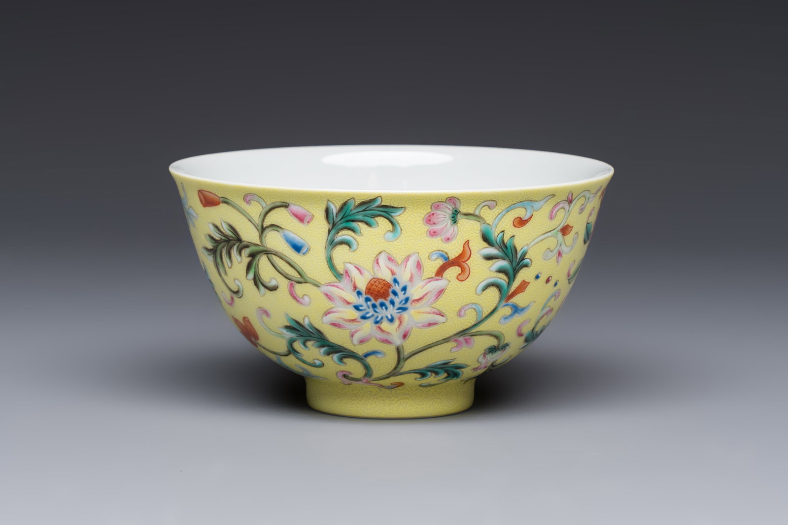 A Chinese famille rose sgraffito lemon-yellow-ground 'Flower Scrolls' bowl, Qianlong mark, 20th C. (1 of 7)