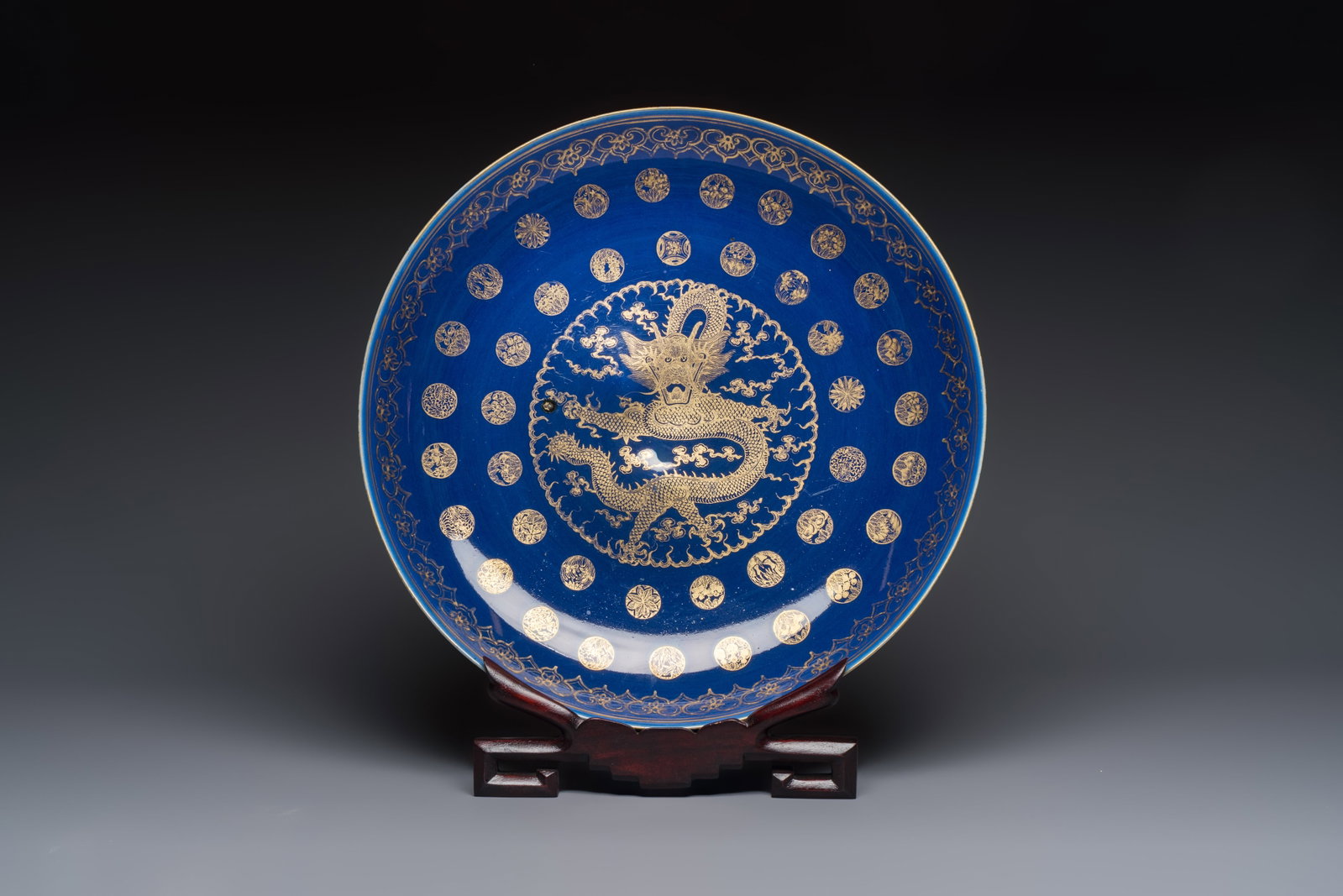 A large Chinese gilt-decorated powder-blue-ground 'Dragon' dish on a later wooden stand, Guangxu (1 of 4)